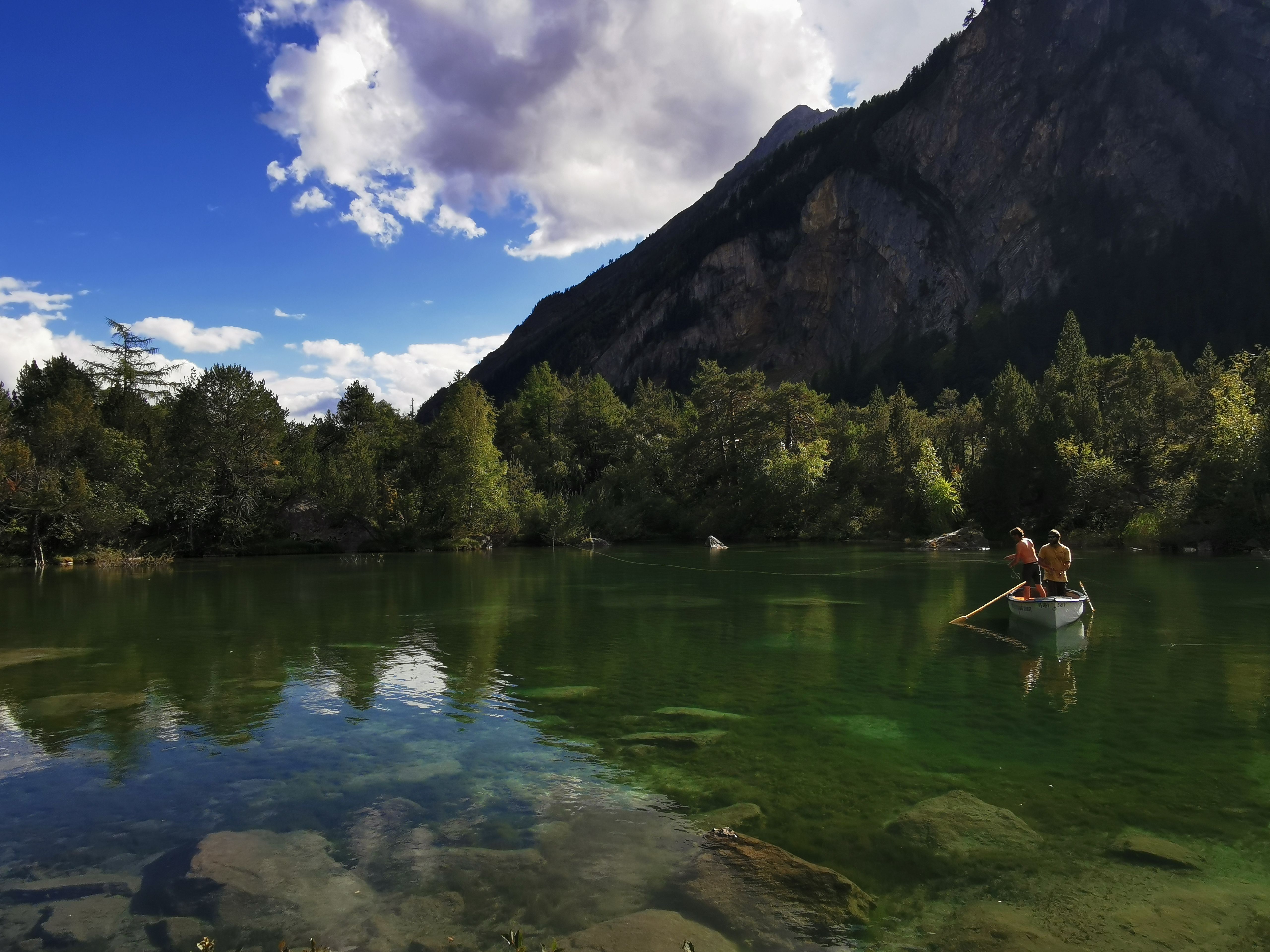 Derborence: lugn paddling i klart vatten omgivet av berg och gröna skogar.