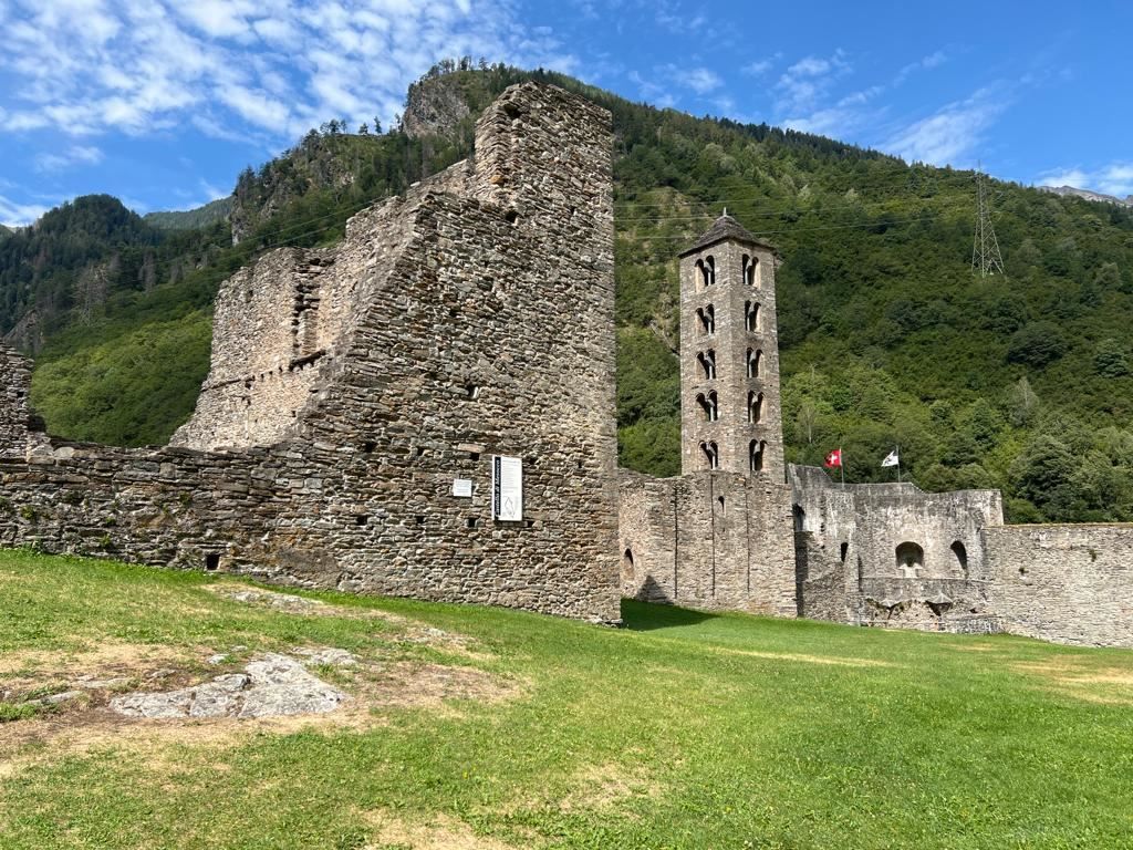Misox: An impressive castle ruin surrounded by green mountains in nature.