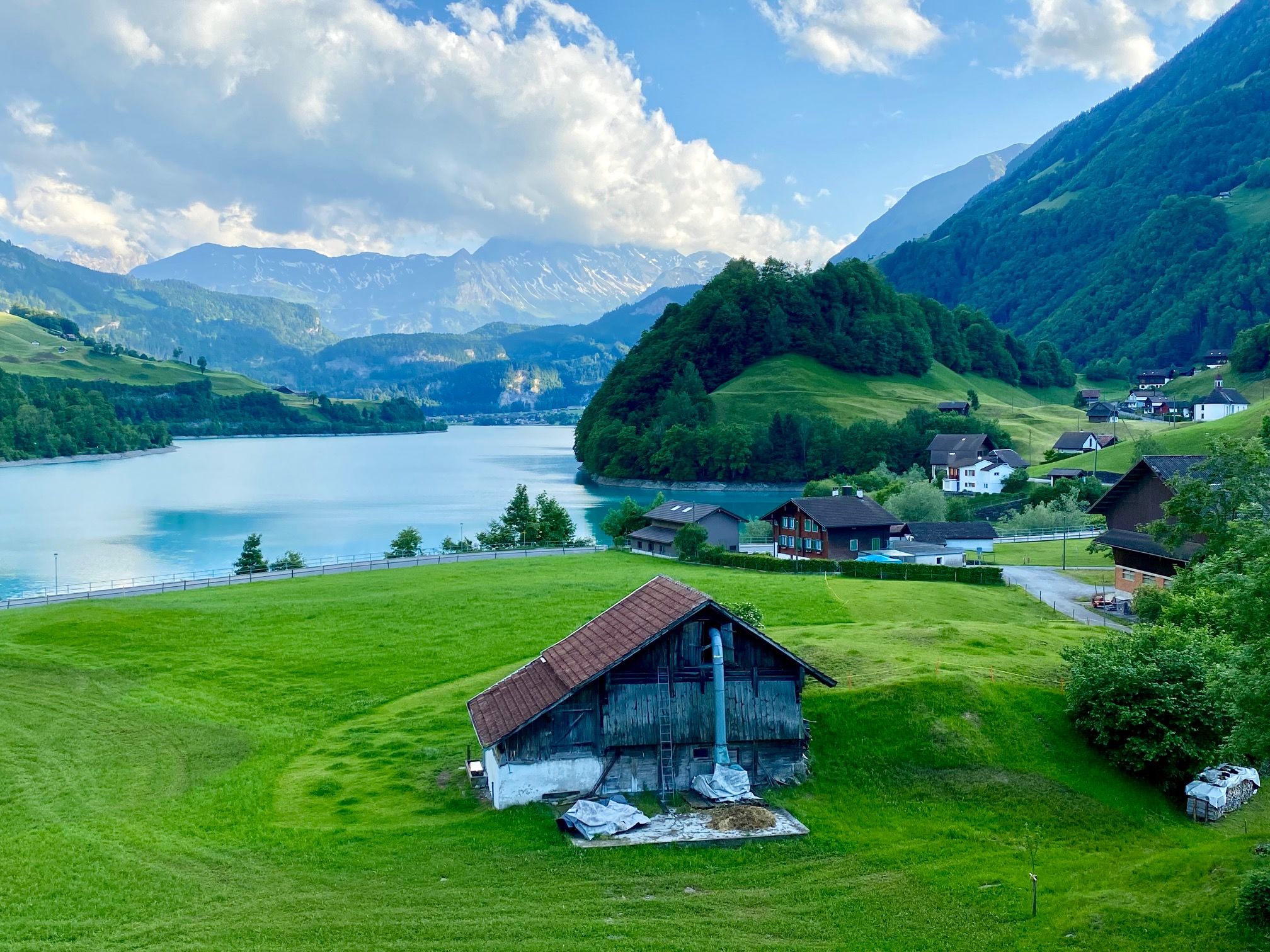 Jungfrau region: malebná krajina s horami, jezery a loukami v letním období.