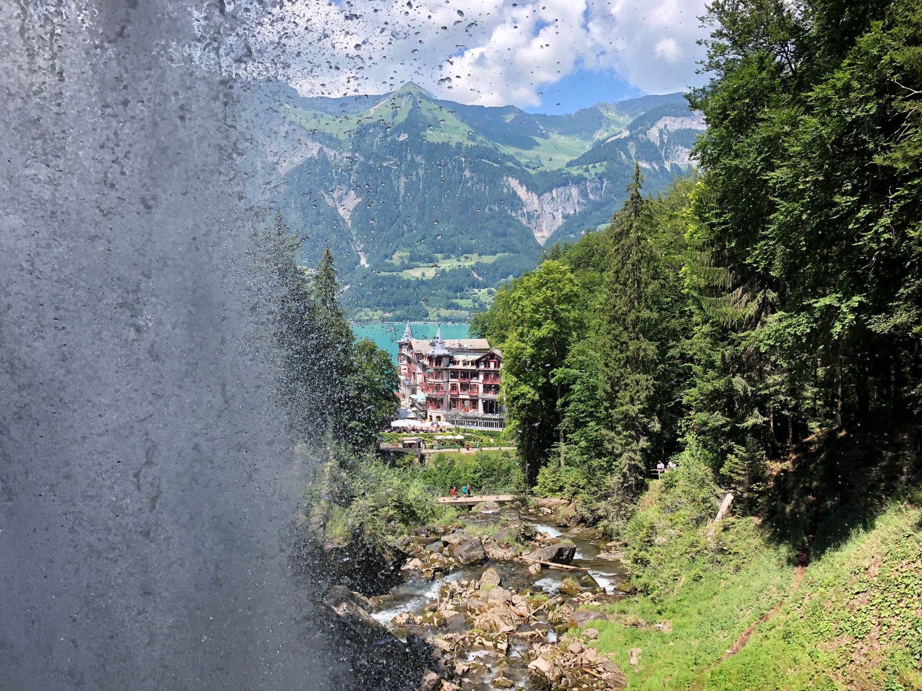 Waterfall in the gorge with a view of the hotel and lake.