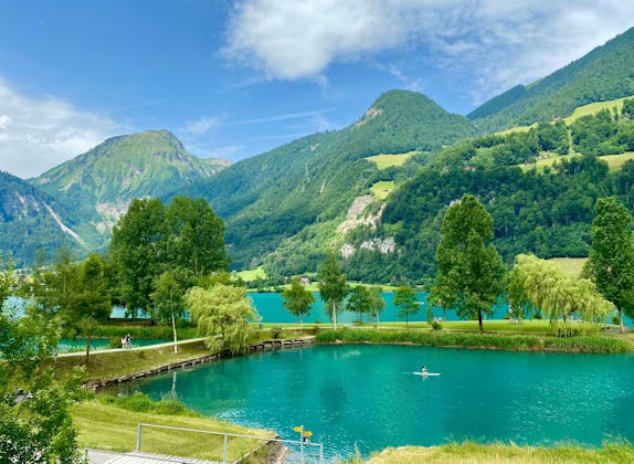 منطقة يونغفراو: بحيرة جميلة مع متزلجين، محاطة بالجبال والطبيعة في فصل الصيف.