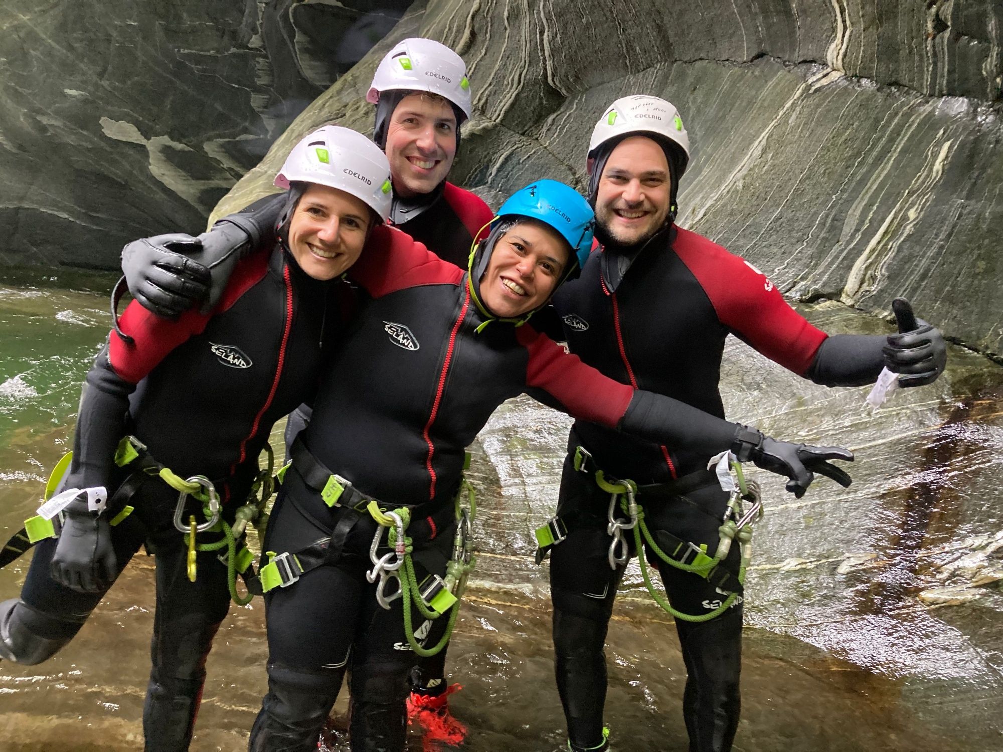 Canyoning nel Maggiatal: Team in muta al fiume in estate, vivere avventura e natura.