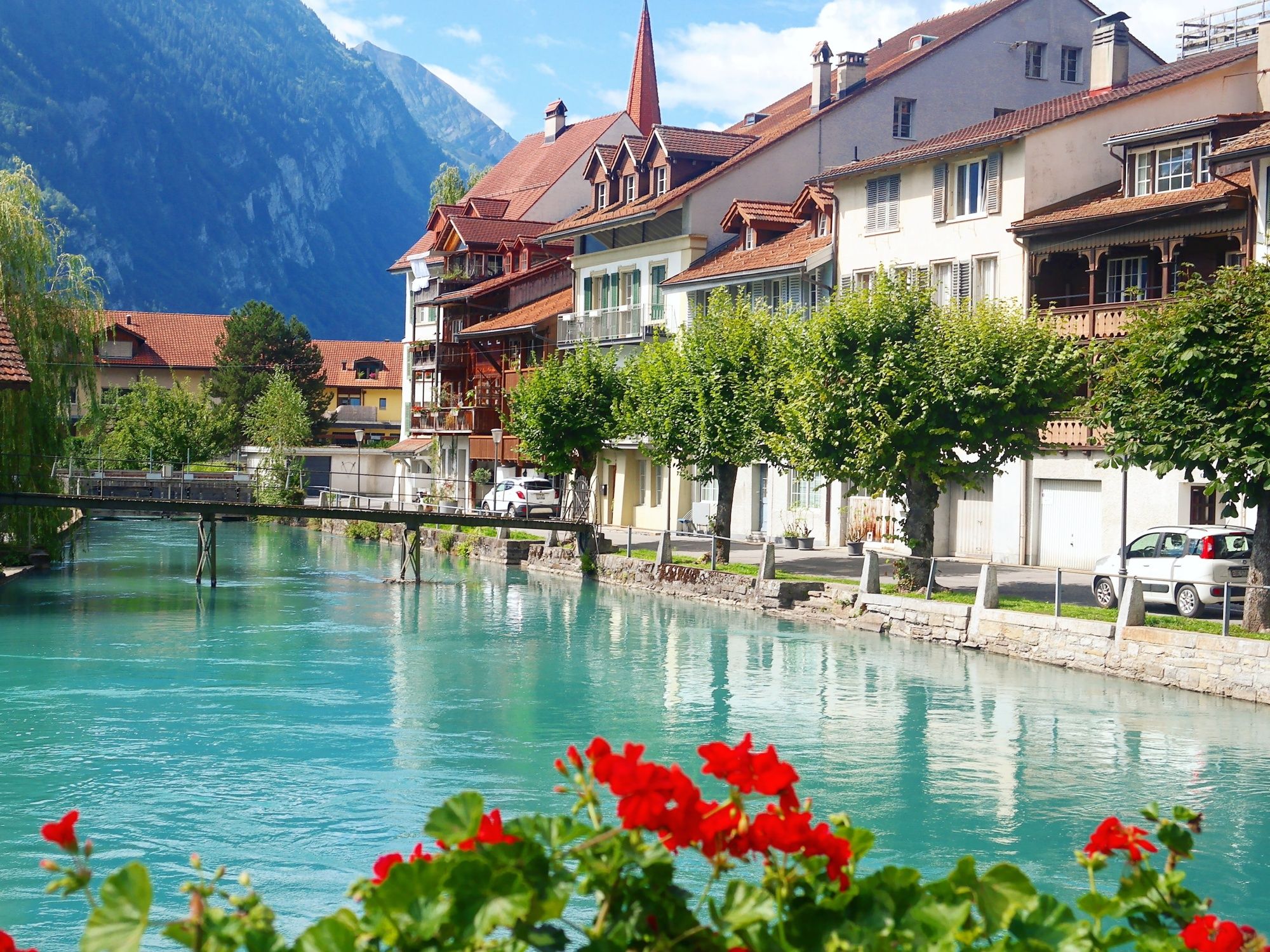 Interlaken: idyllic landscape with water, houses, and blooming flowers in summer.