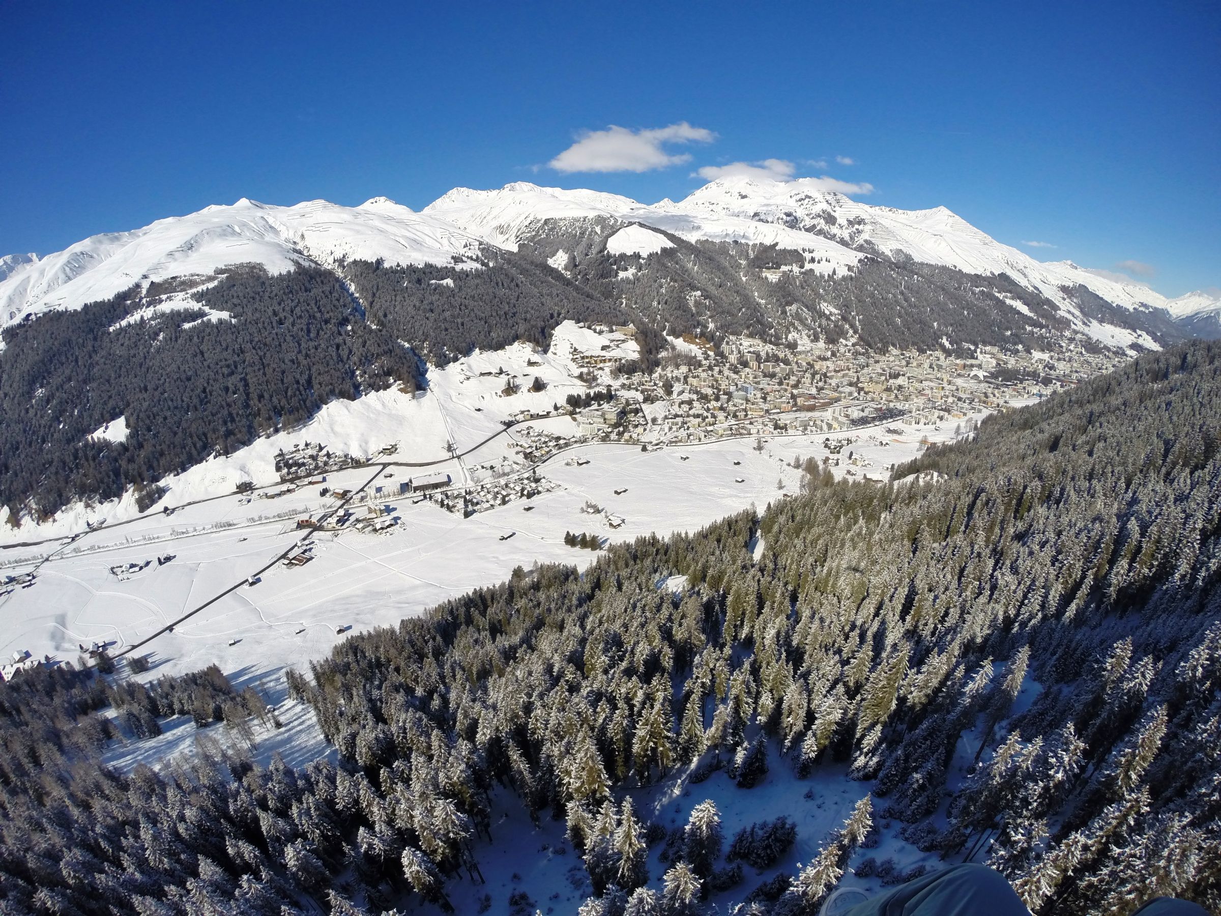 Davos in prospettiva a volo d'uccello con montagne innevate e foreste d'inverno.
