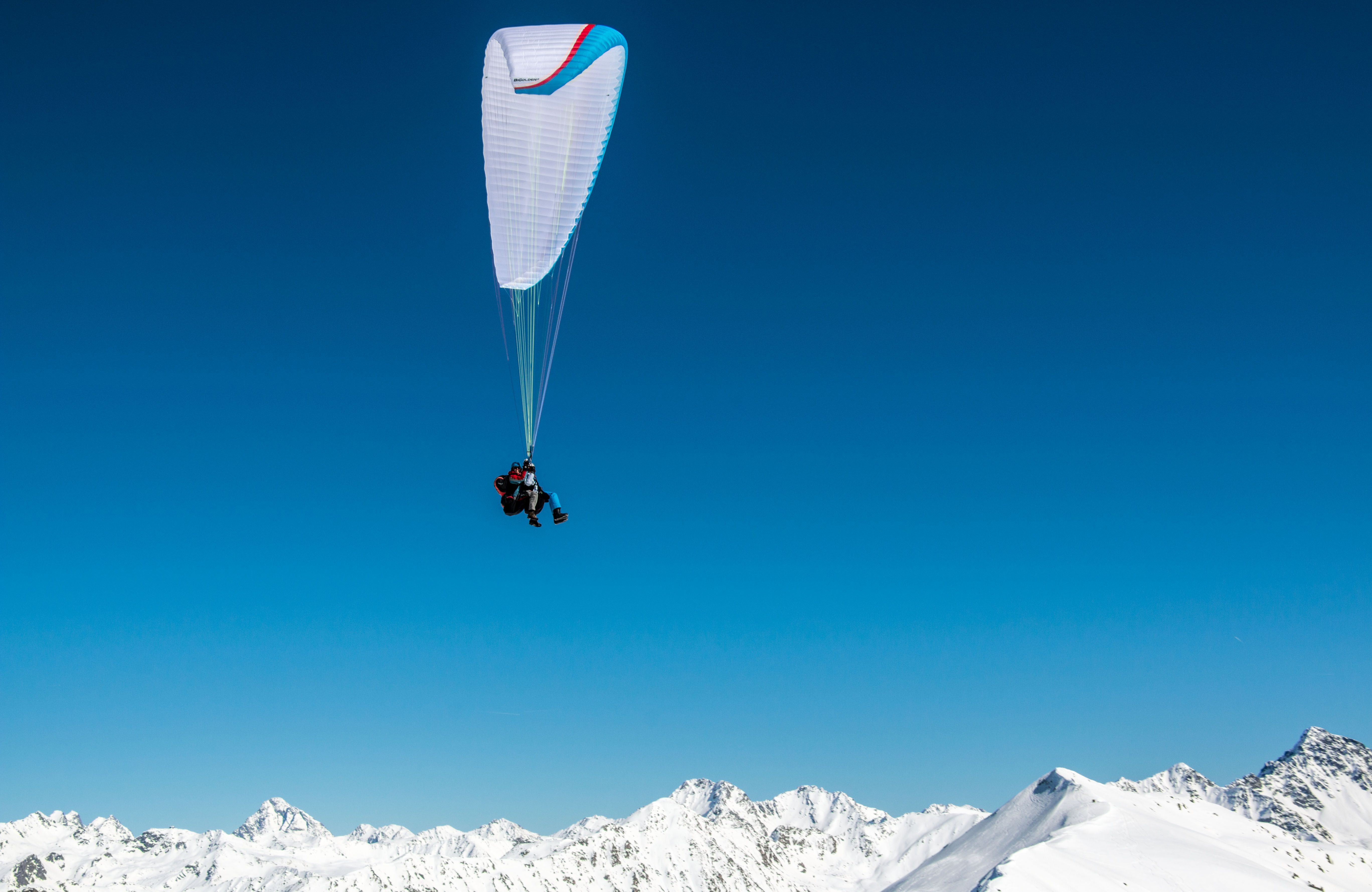 Tandemvlucht parapente Klosters in de winter boven besneeuwde bergen.