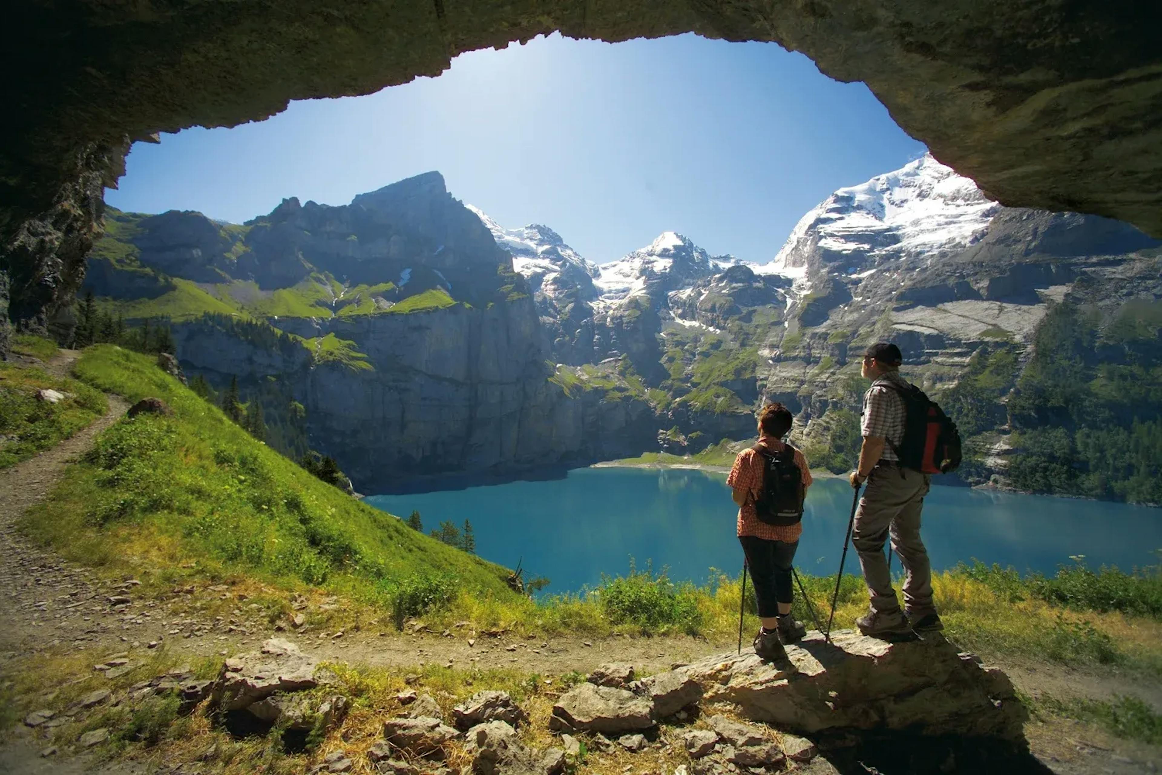 Viajantes olham para o Oeschinensee e as majestosas montanhas em Kandersteg.