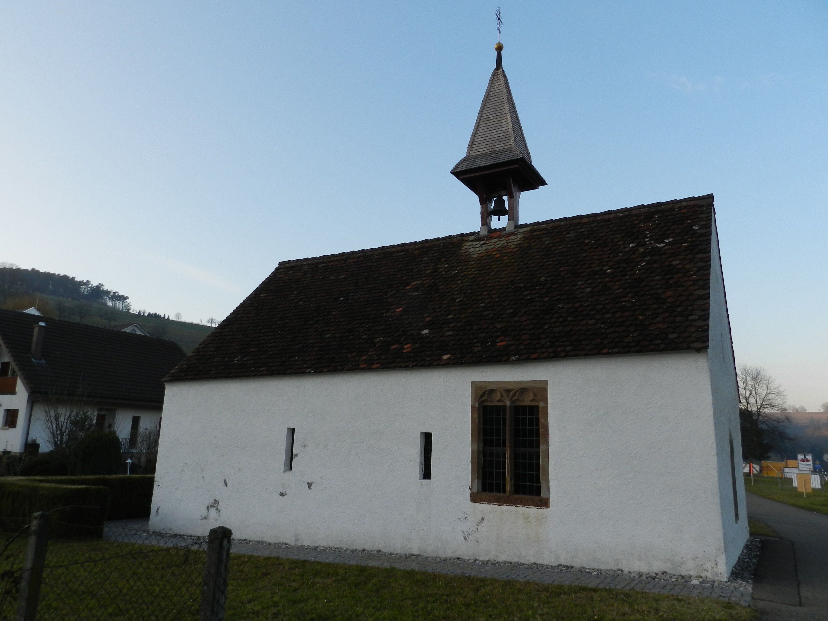 Kapeller og kirker i Herznach med historisk klokkestabel og snehvid facade.
