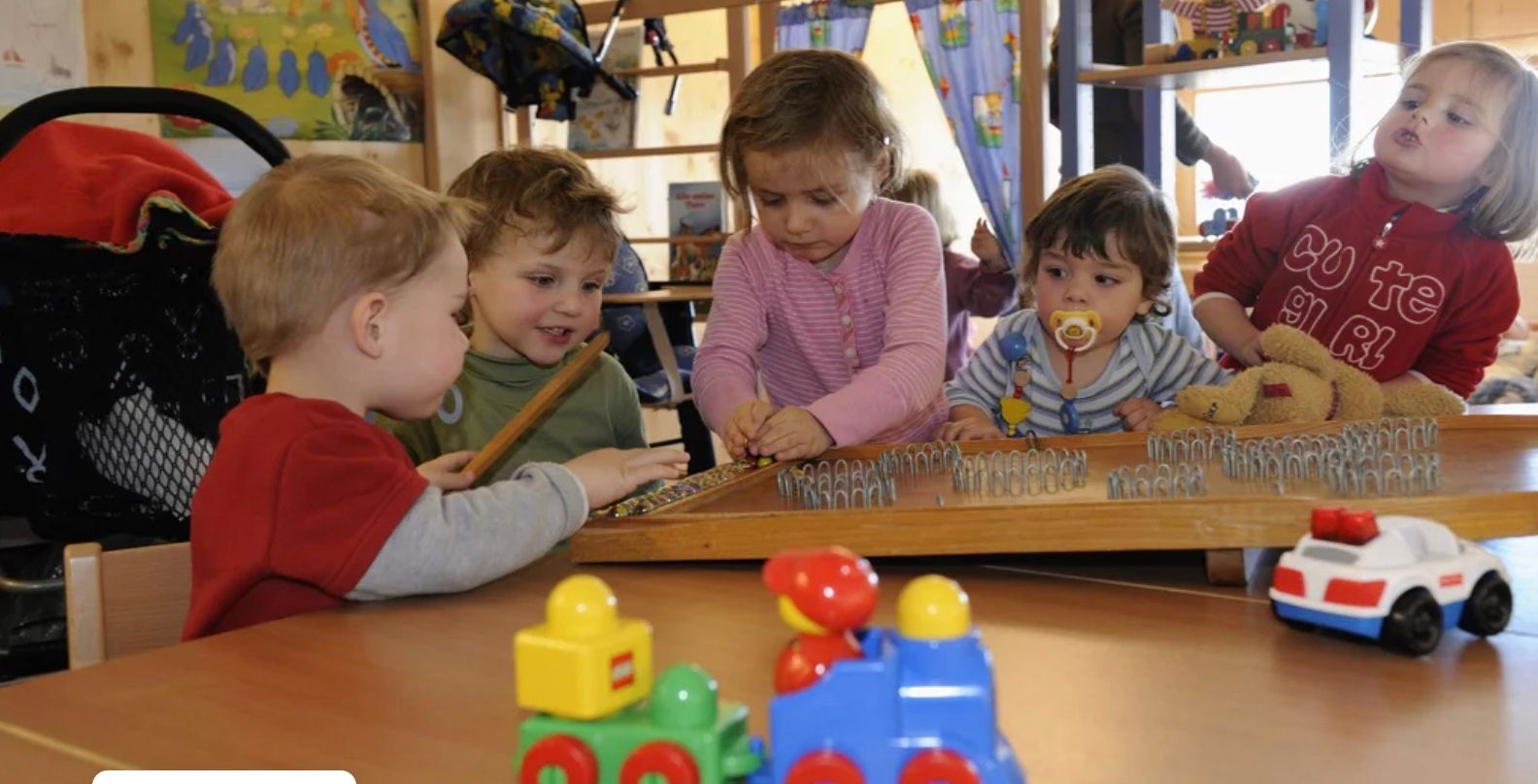 Cuidado infantil: As crianças brincam com brinquedos e fazem artesanato numa atividade em grupo numa instituição.