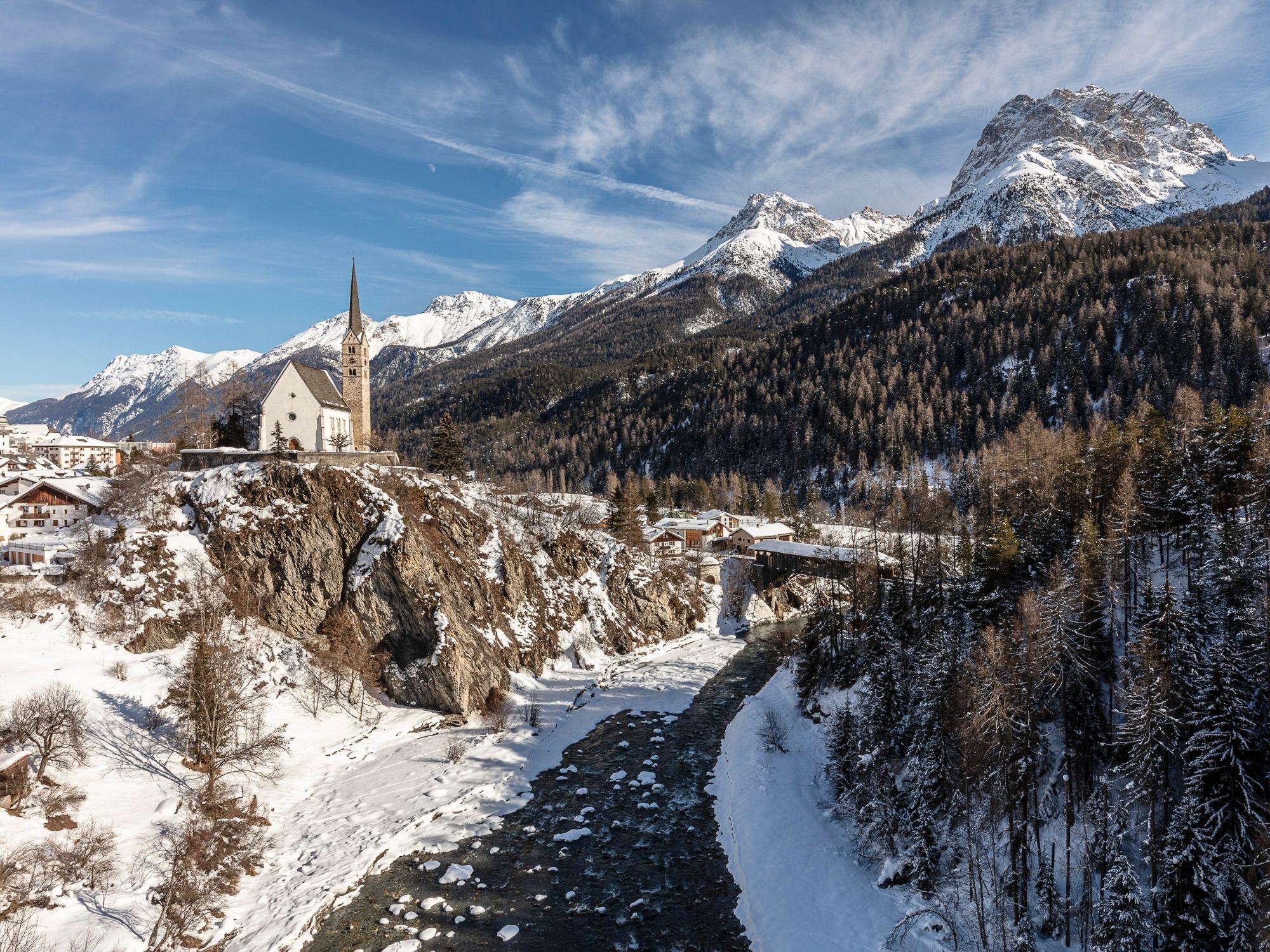 Église de Scuol en hiver avec des montagnes enneigées