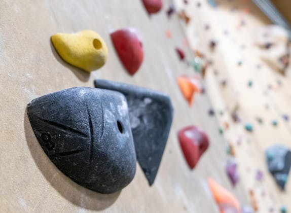 Parede de escalada: Escalada indoor em Zermatt com agarras coloridas e rotas desafiadoras.