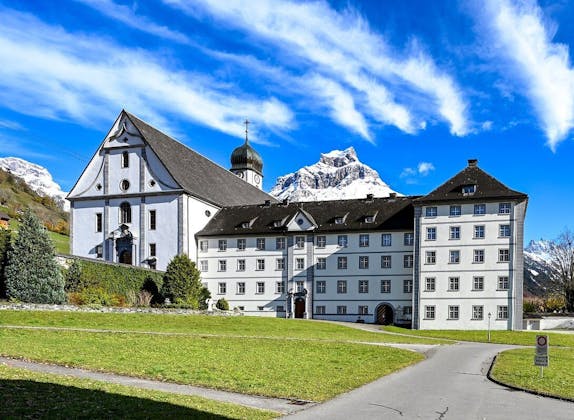 Biara Engelberg dengan pemandangan pegunungan di latar belakang, lingkungan hijau