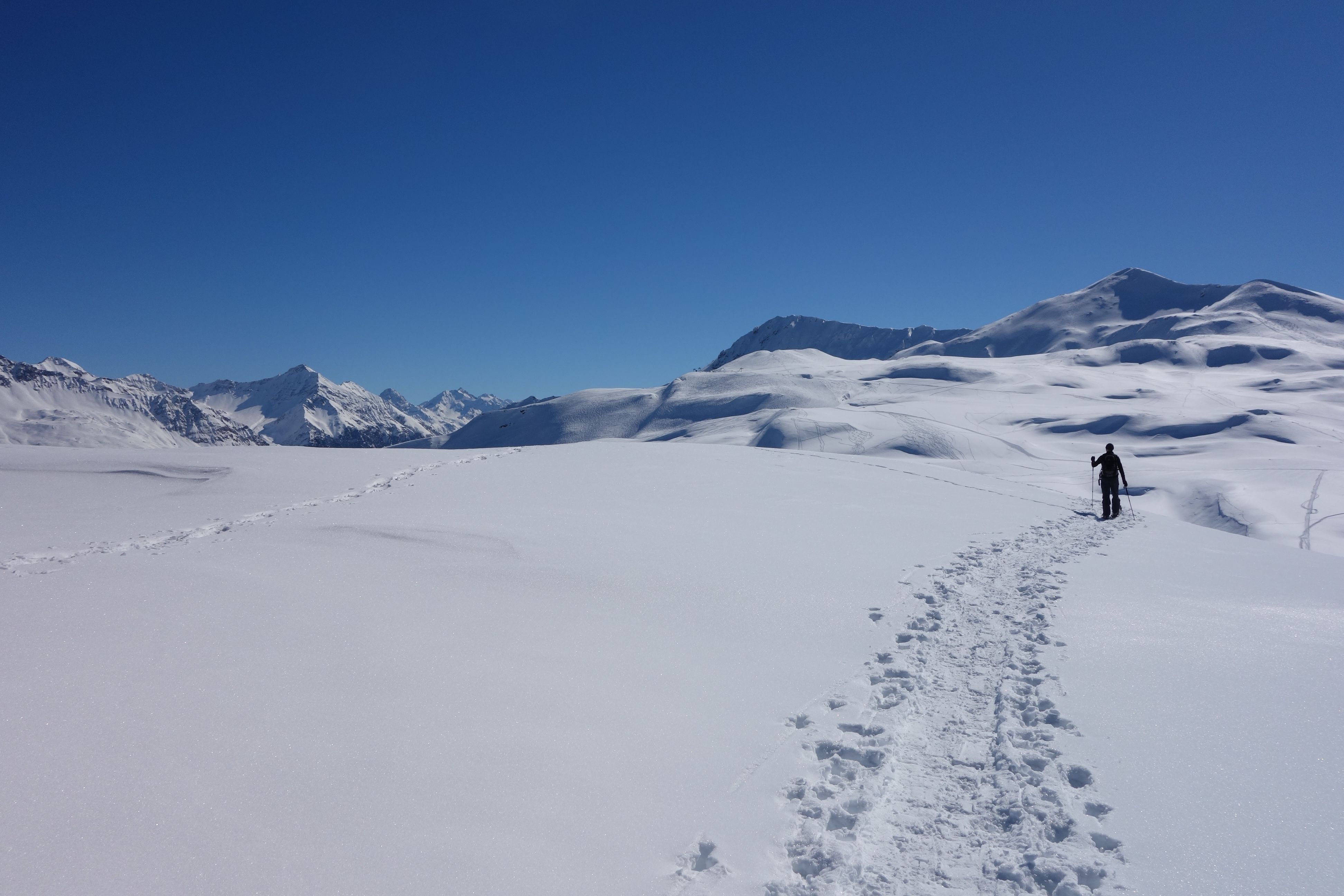 Monde d'hiver : randonneur marchant à travers la neige vierge dans les montagnes.