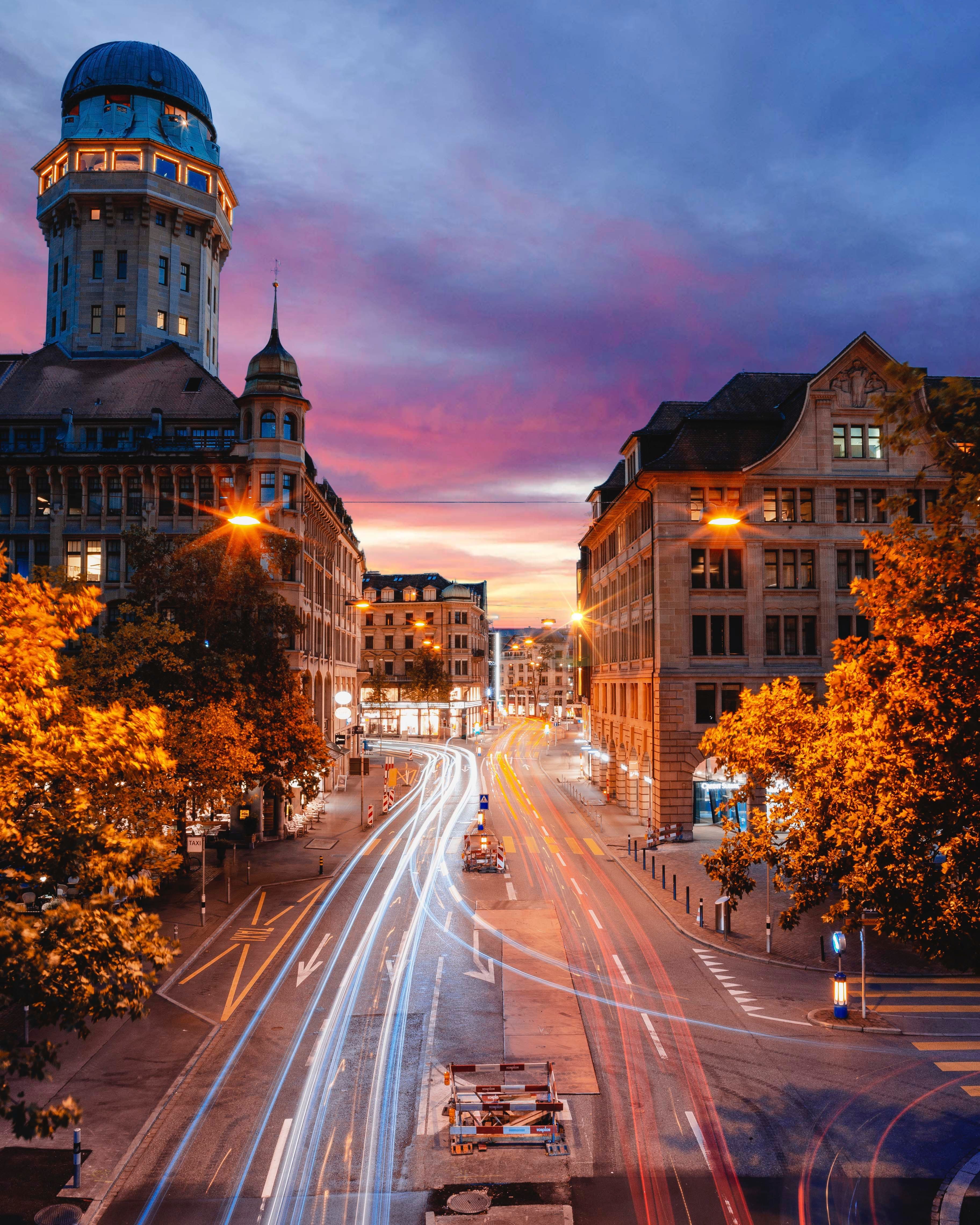 Vue de la ville avec des lumières et des rues au coucher du soleil, parfaite pour la photographie urbaine et les prises de vue nocturnes.