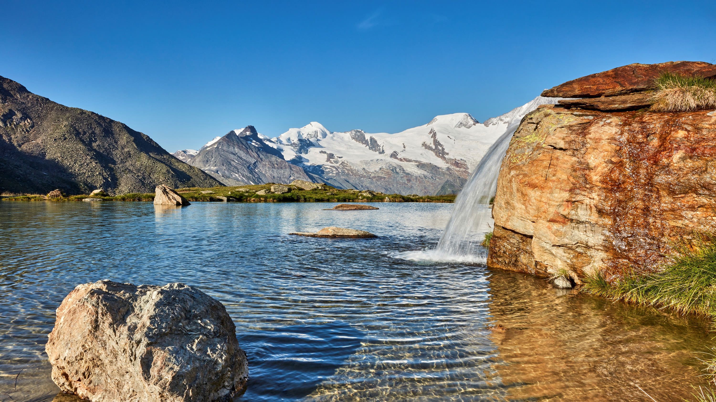 2023 में जलप्रपात और आल्प्स के नज़ारों के साथ क्रॉज़बोडेन झील।