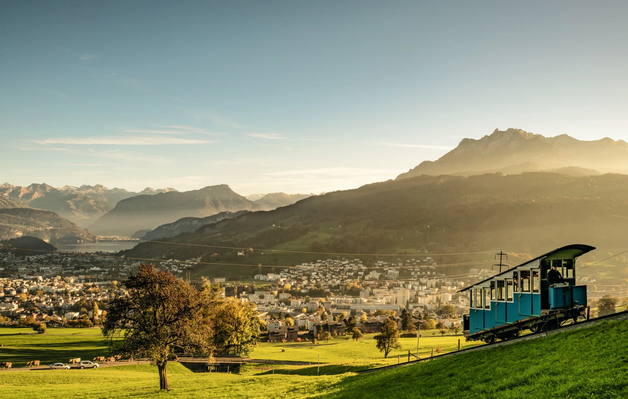 Widok na Kriens z górskim krajobrazem, zielonymi łąkami i pociągiem