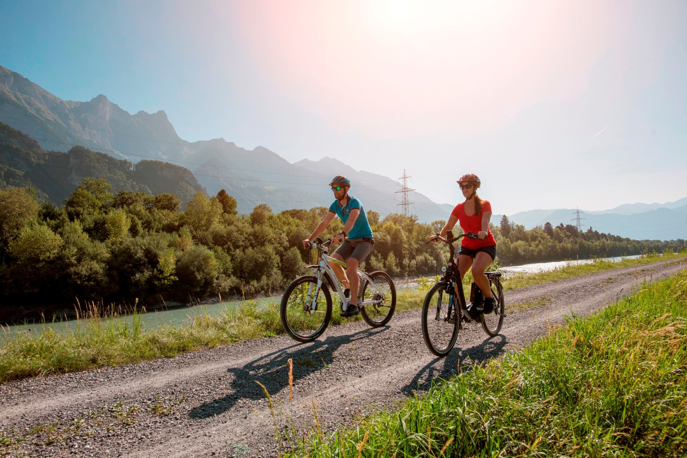 Kulinarik-Tour Bündner Herrschaft: Radfahrer auf dem Weg entlang des Flusses in der Natur.
