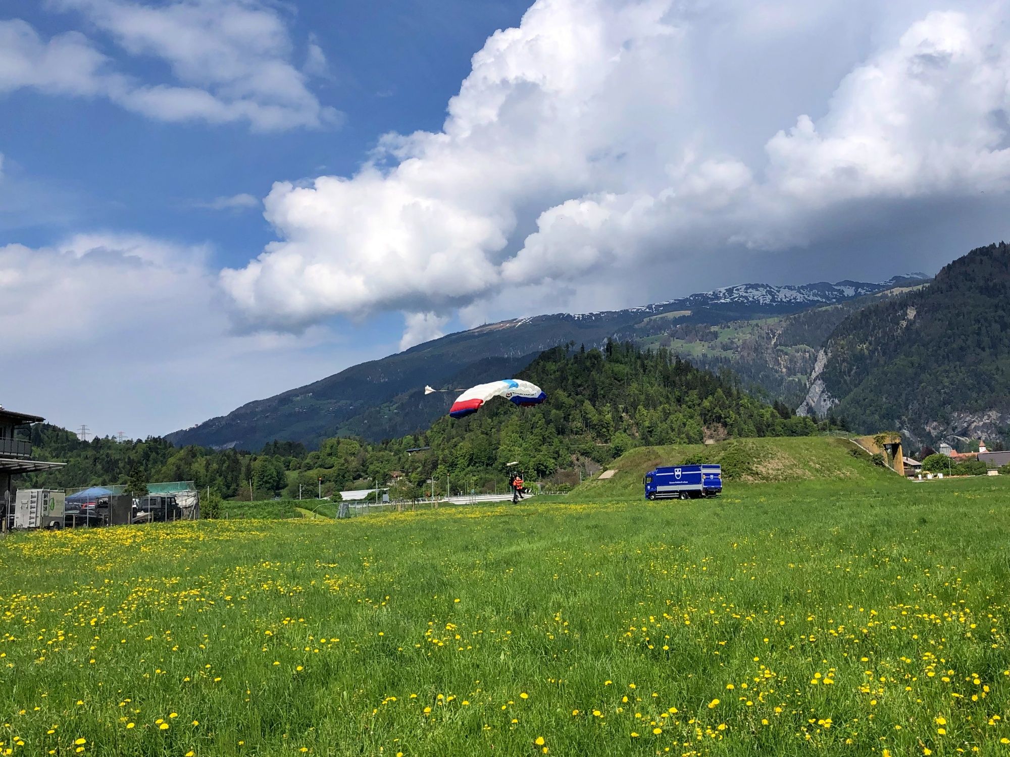 Skydive Interlaken med fallskärmsparaglidare på grönt fält.