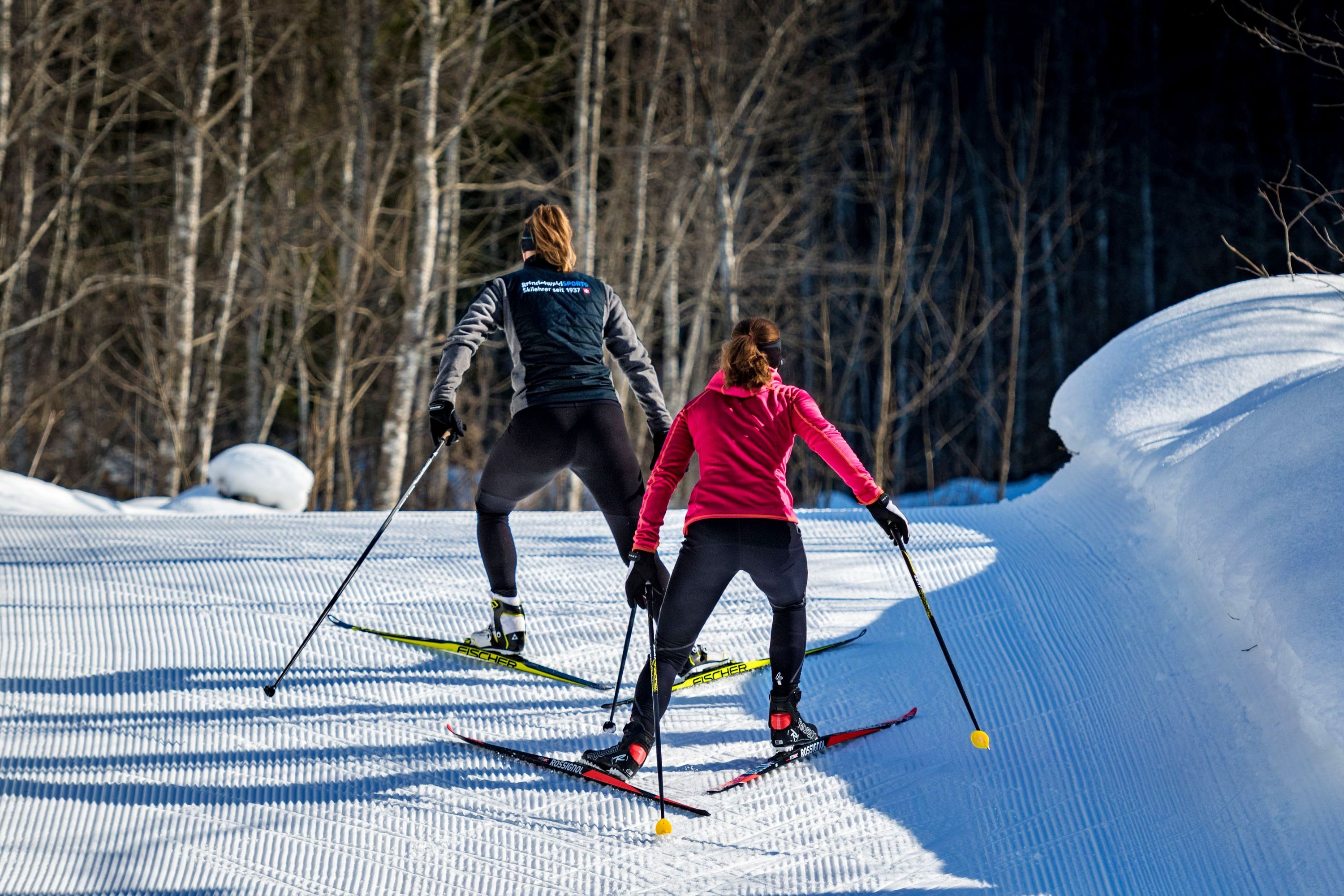 Kursus pribadi ski lintas alam di Grindelwald, dua wanita sedang skating, jalur salju tertutup salju