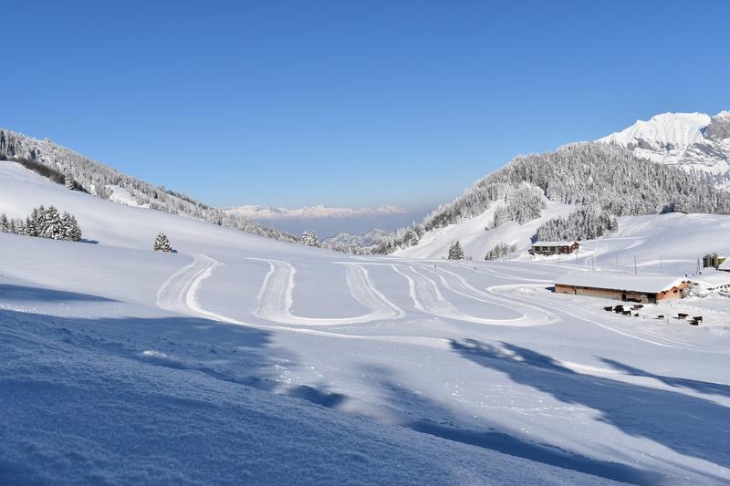 Langrennsløype svinger i fantastisk vinterlandskap med snødekte fjell.
