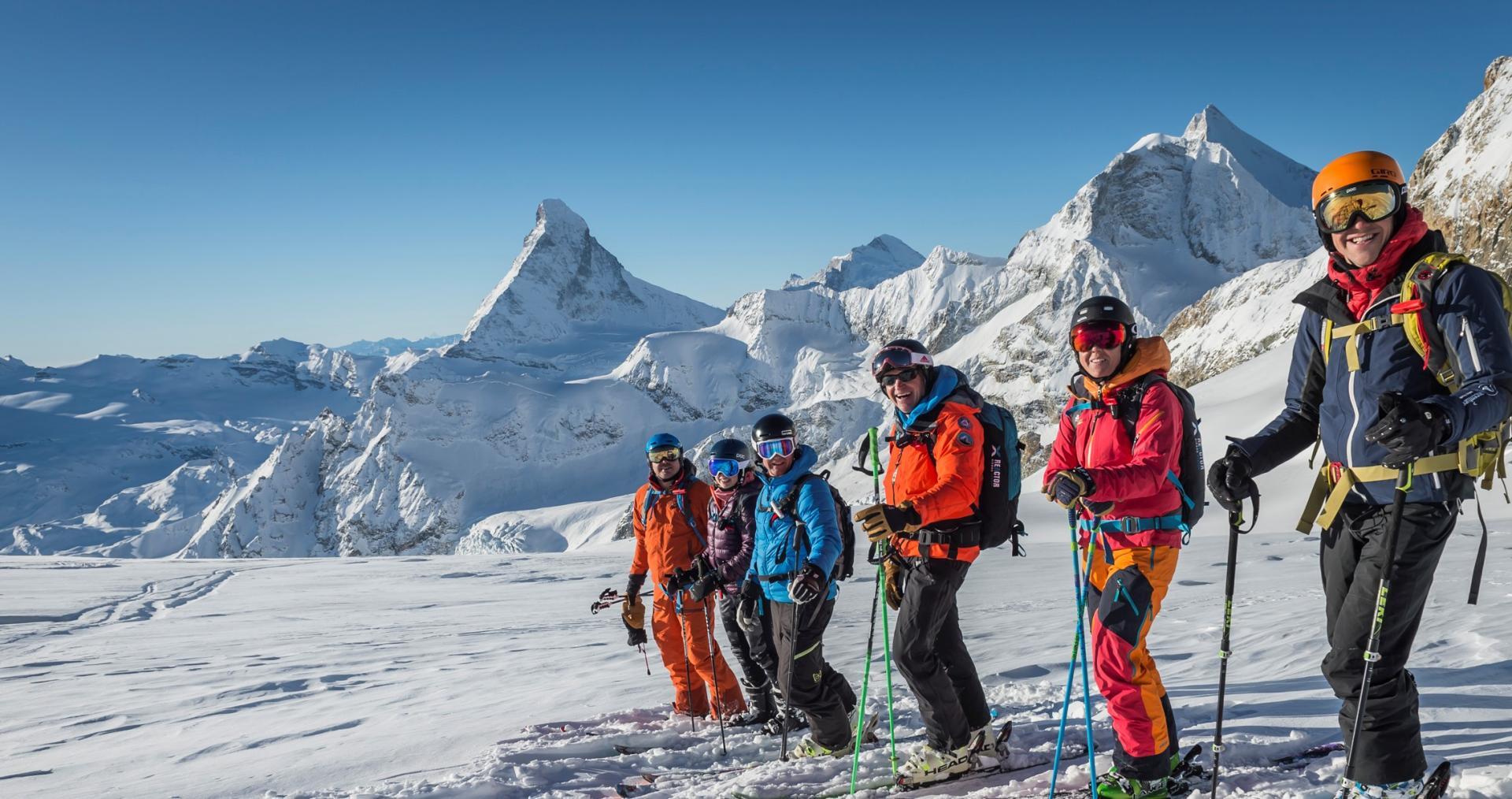 Cours d'avalanche : groupe en train de skier dans les montagnes en hiver avec de la neige et une excellente visibilité.