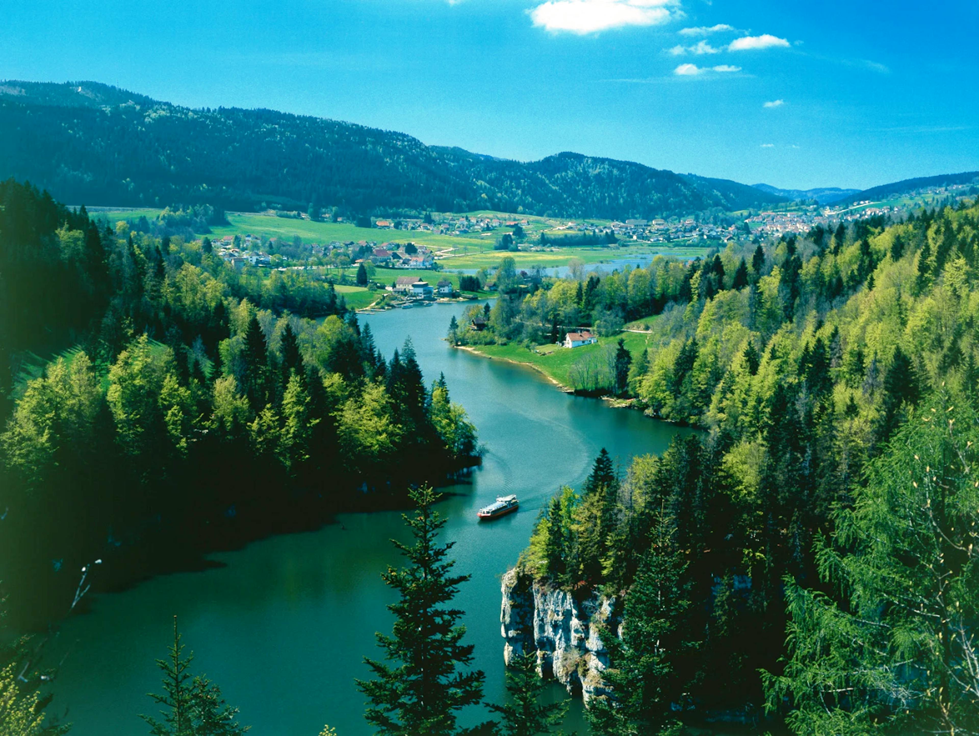 ले लोکل। नदी का मनोहर दृश्य, पेड़ों और पहाड़ों से घिरा हुआ वसंत में।