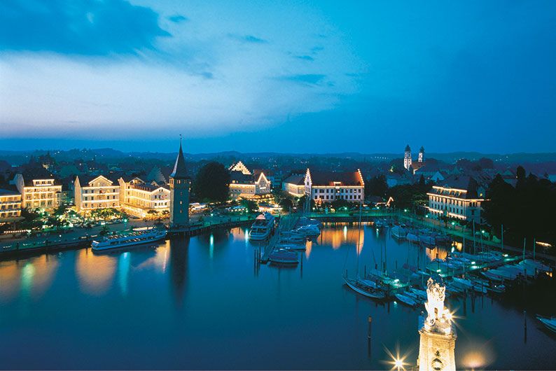 林道的夜晚展示了灯光璀璨的建筑、游艇和宁静的水域