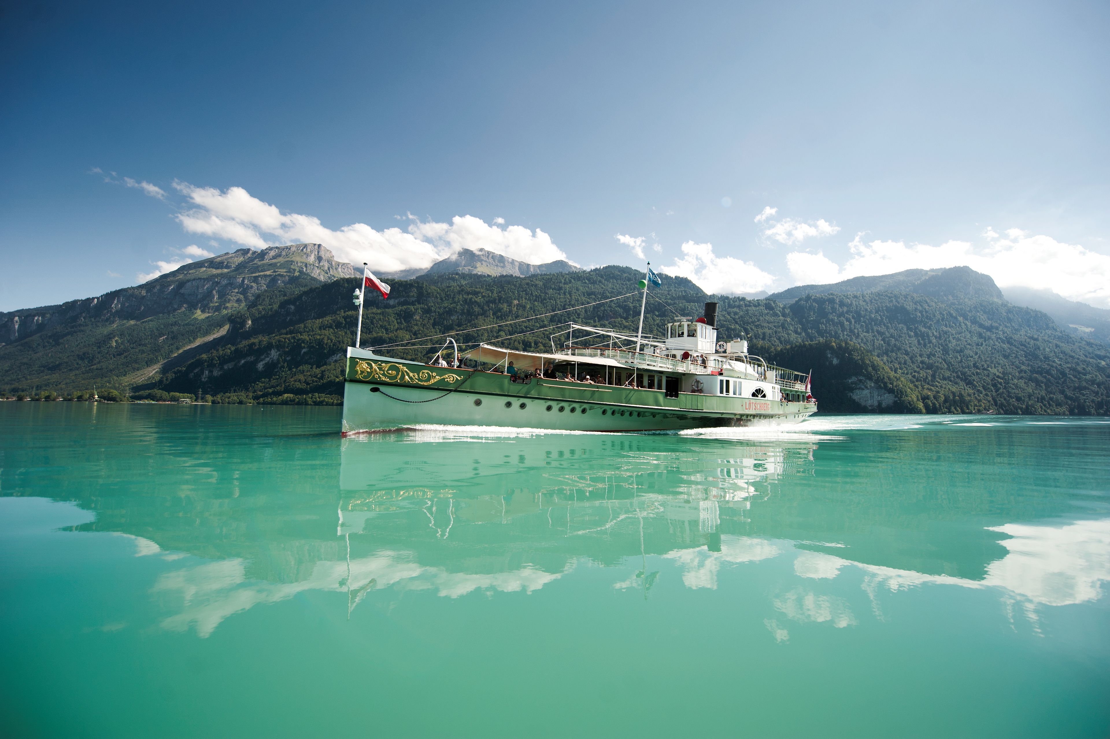 Tageskarte Brienzersee mit einem Schiff auf dem Wasser und Bergblick.