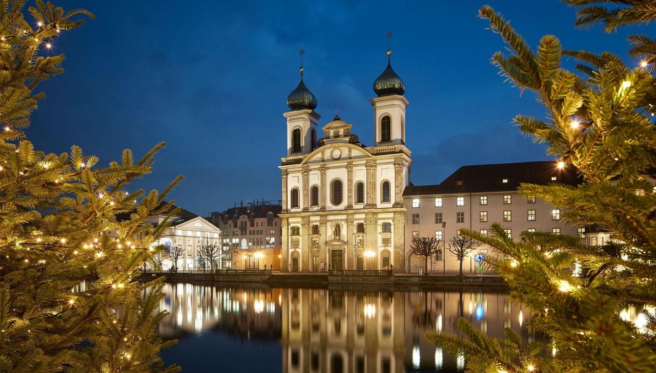 Lawatan bandar Luzern dengan pencahayaan Krismas di tepi air bersama gereja dan pokok-pokok.
