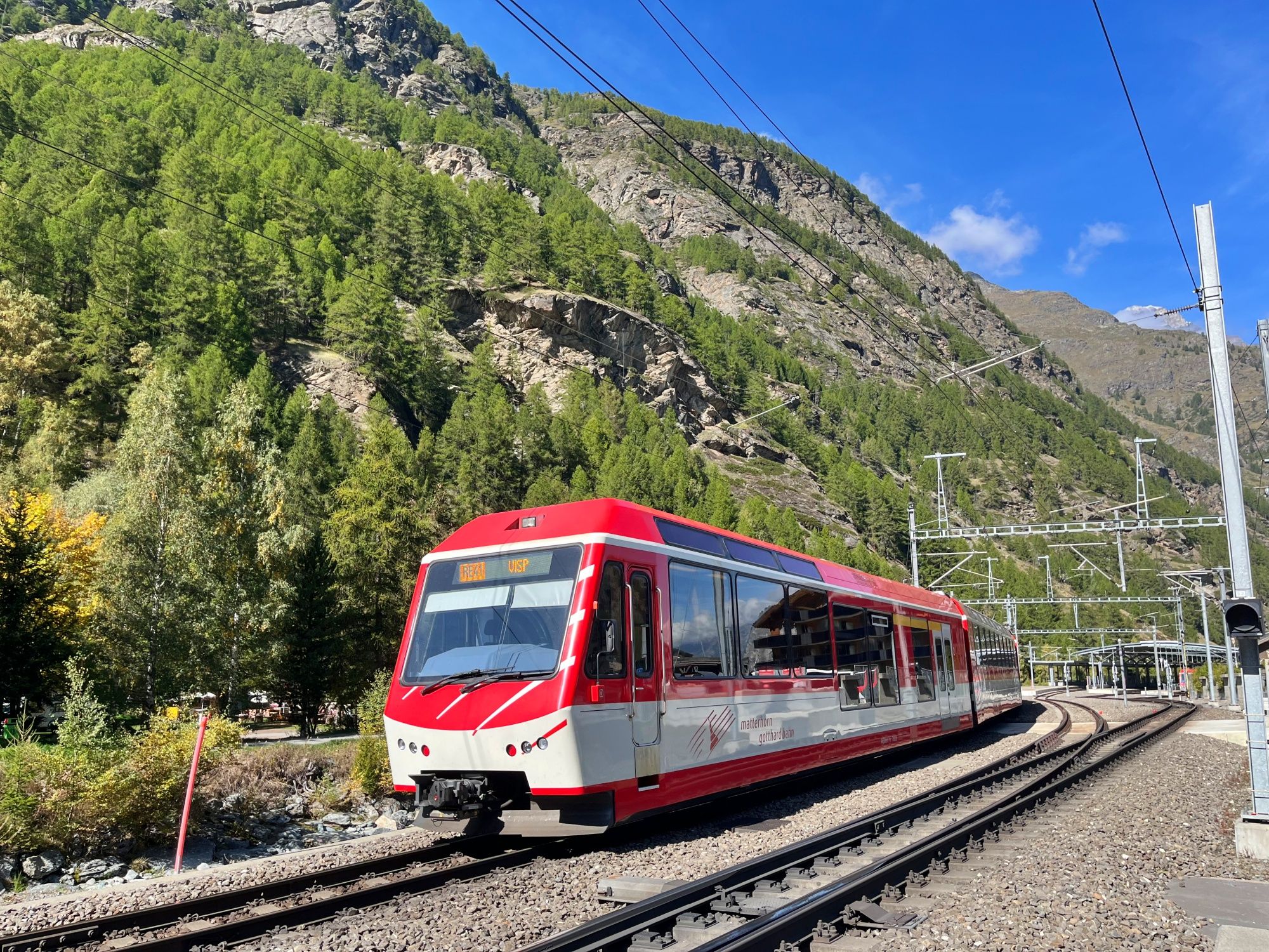 Bahnverbindung im Tal zwischen hohen Bergen, ideal für Ausflüge in die Natur.