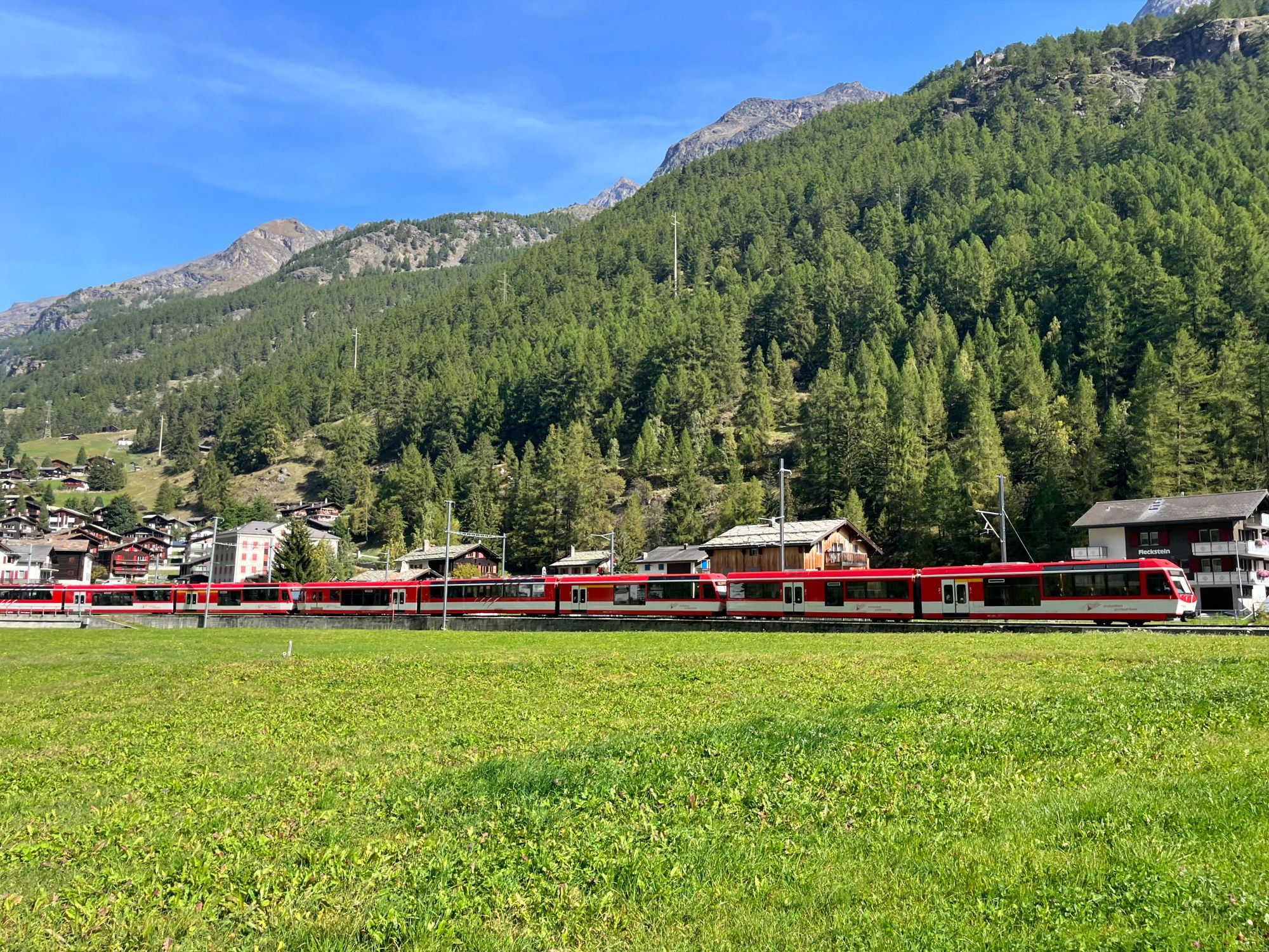 Train traverses the nature in Zermatt, surrounded by mountains and forests. Ideal for adventures and group activities.