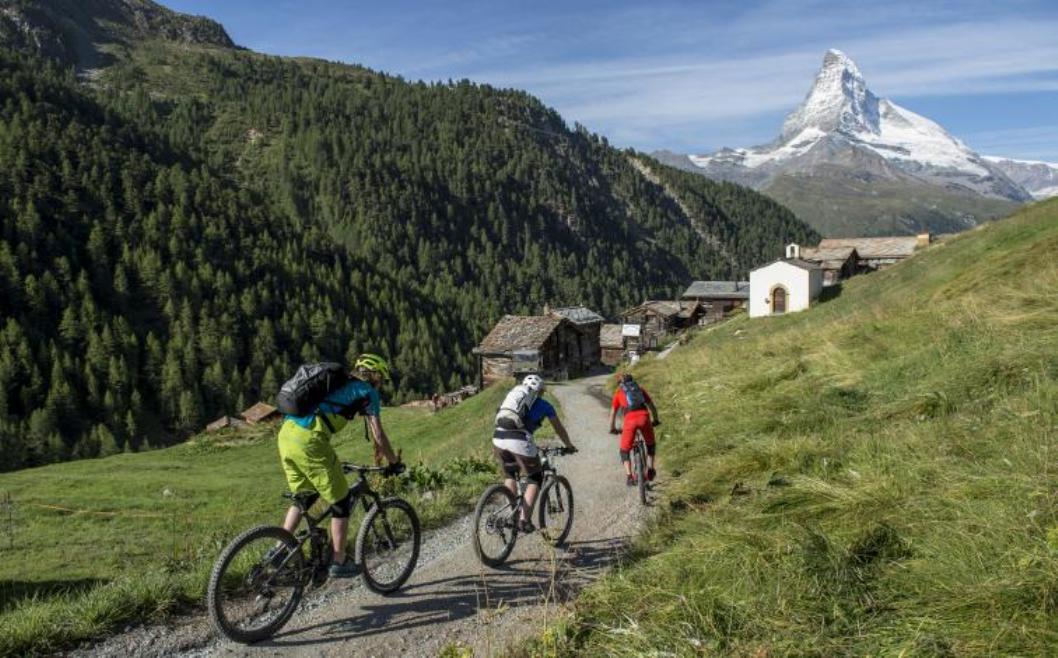 MTB Dasar: Pengendara gunung mengendarai sepeda di Zermatt dengan pemandangan pegunungan dan alam.