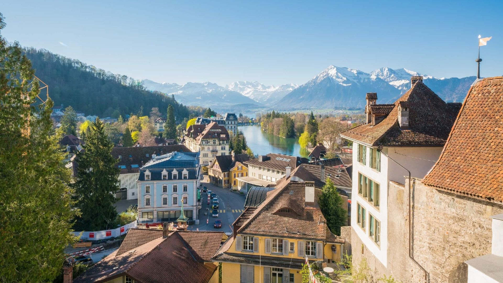 Lawatan bandar Thun bersama lelaki dan wanita, pemandangan gunung dan bangunan pada musim bunga