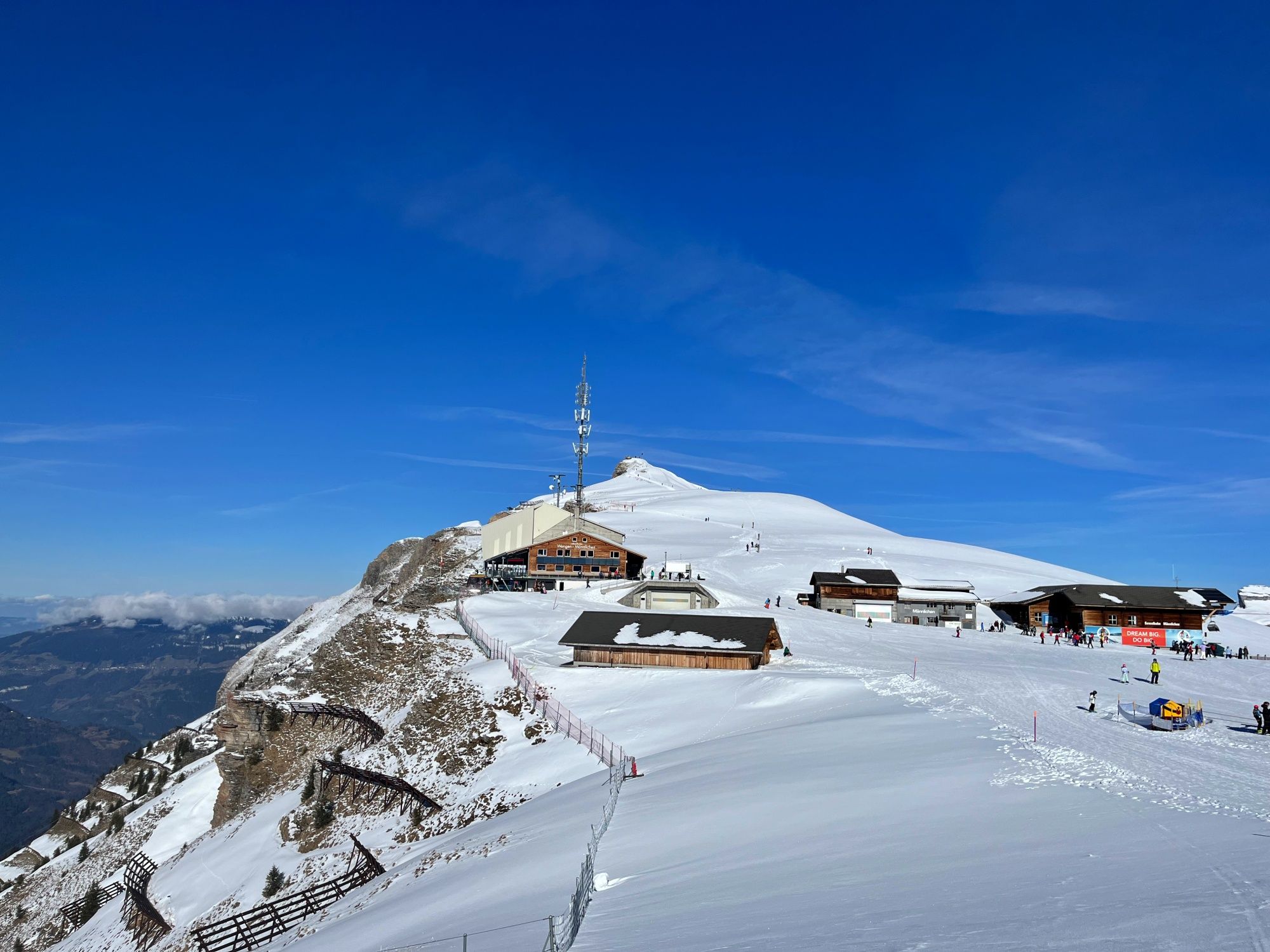 Männlichen: Stanice lanovky s cestou na vrchol v zimě a výhledem na hory.