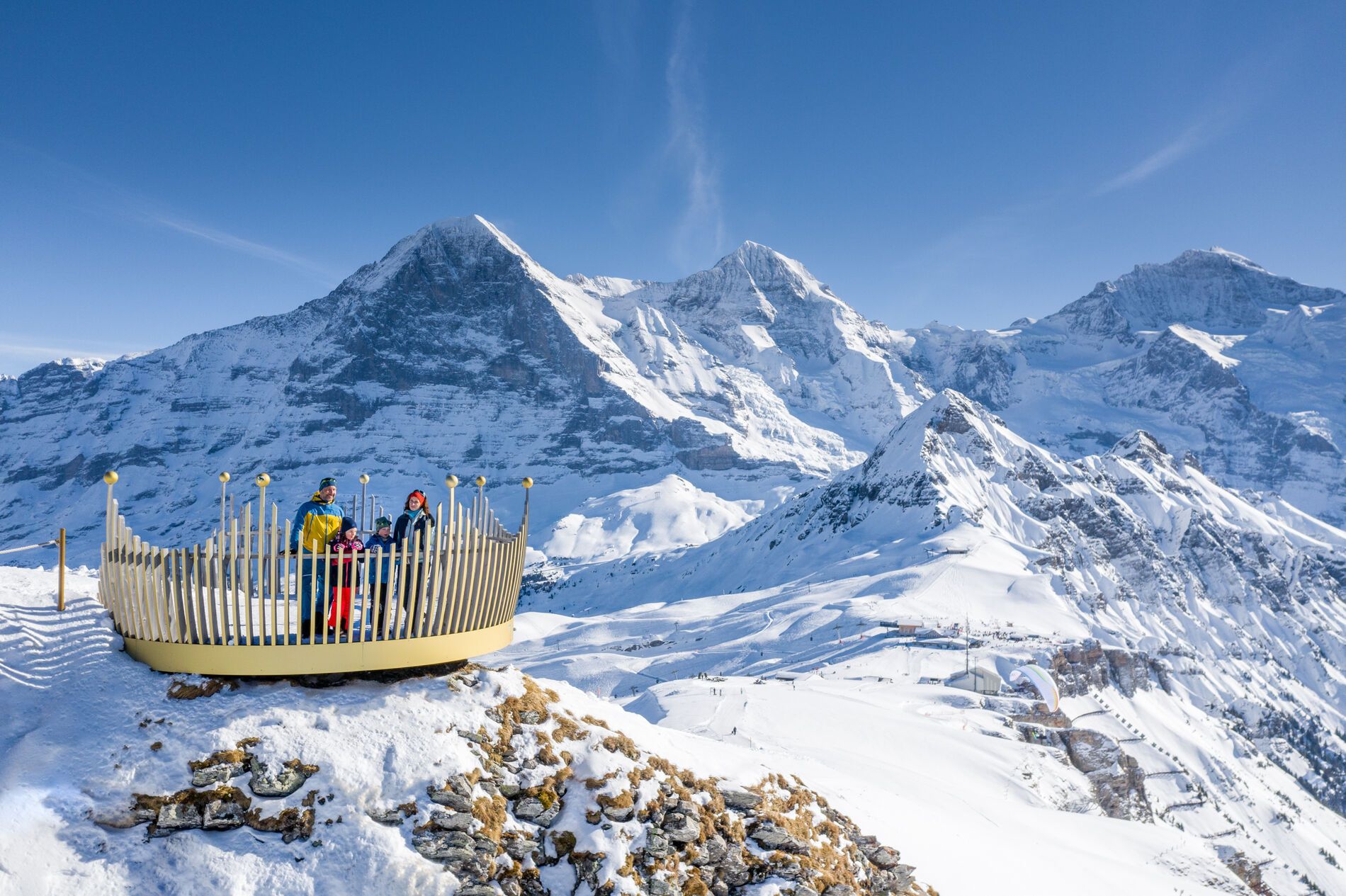 Kereta gantung Wengen menampilkan pengunjung saat menikmati pemandangan Alpen bersalju. Aktivitas musim dingin yang nyaman