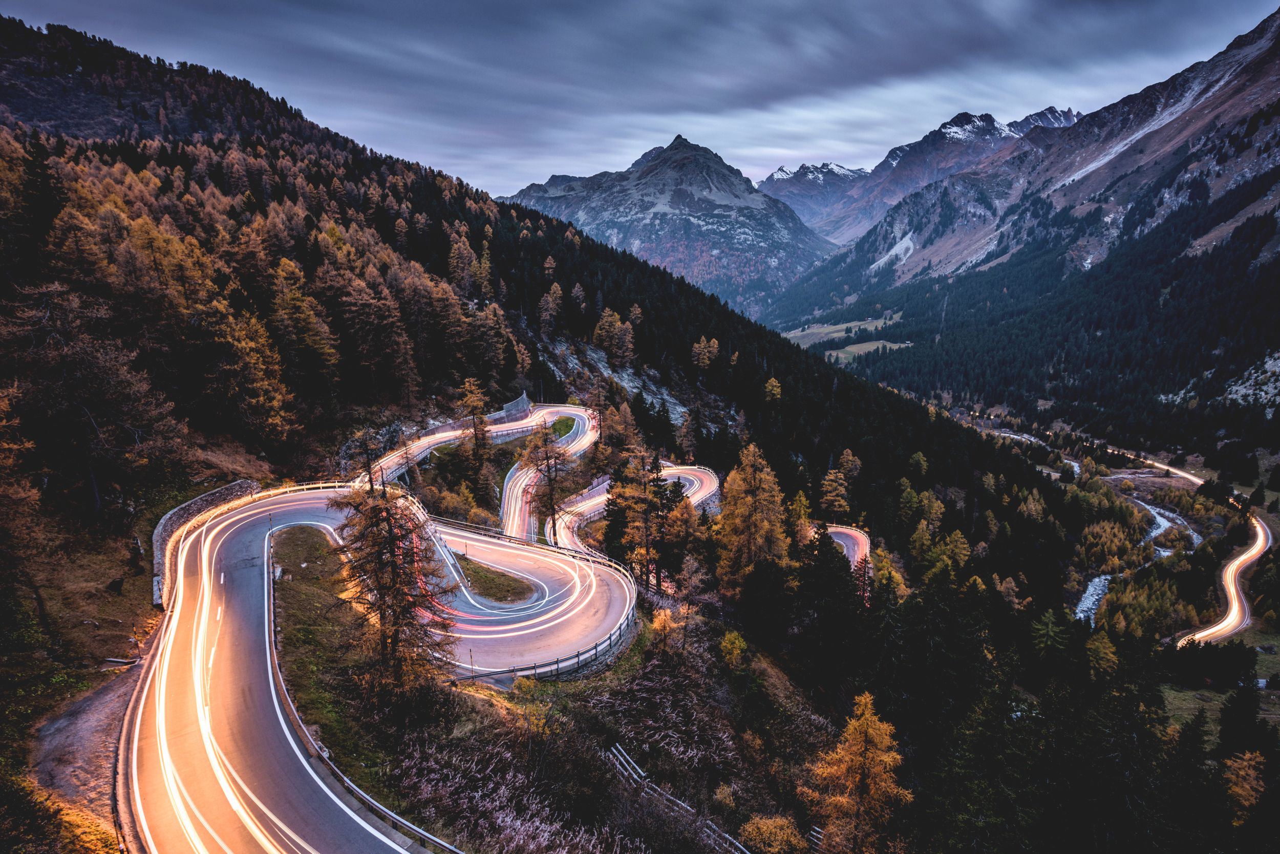 马洛亚山口：夜间曲折的道路，四周环绕着山脉和自然。