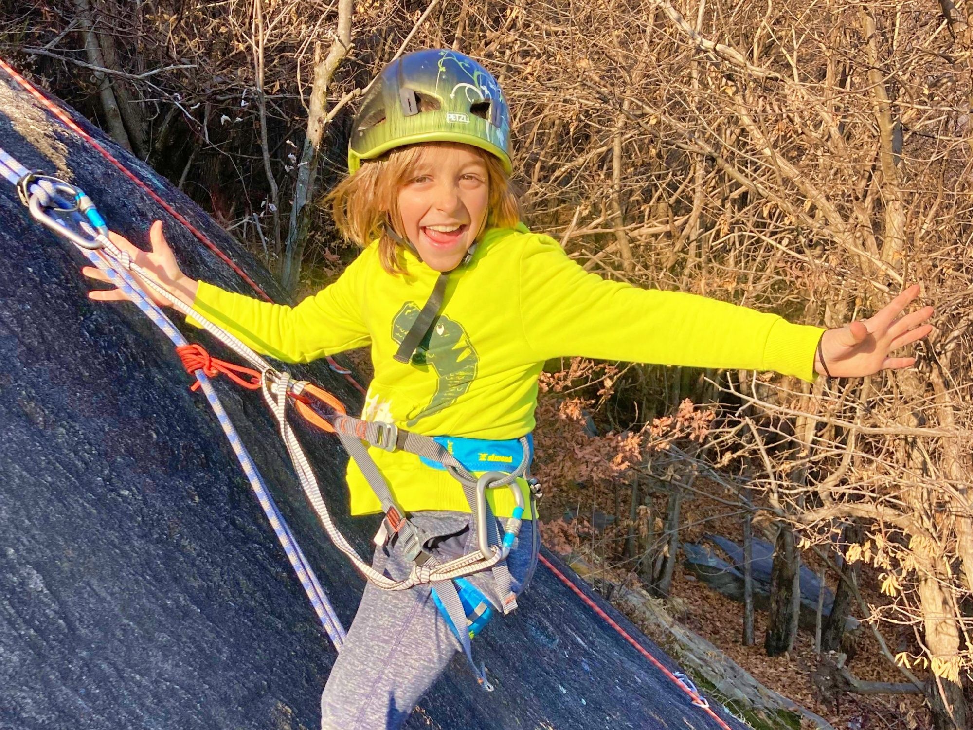 Gezinsklimmen: Mattia klimt enthousiast tegen een muur in de natuur in de zomer.
