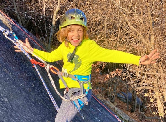 Familieklatring: Mattia klatrer entusiastisk på en væg i naturen om sommeren.