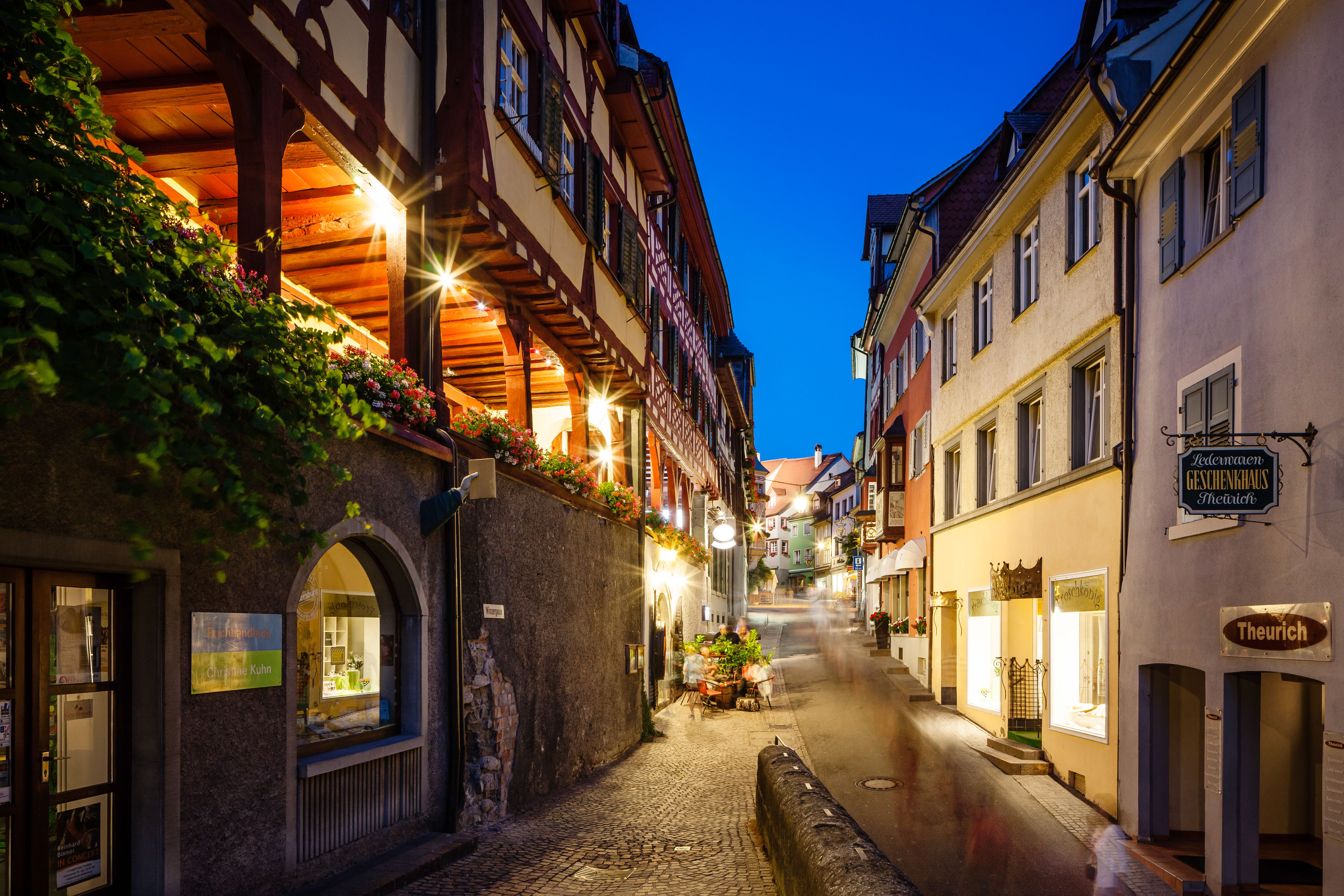 Meersburg nocą z oświetlonymi fasadami, wąskimi uliczkami i historycznymi budynkami