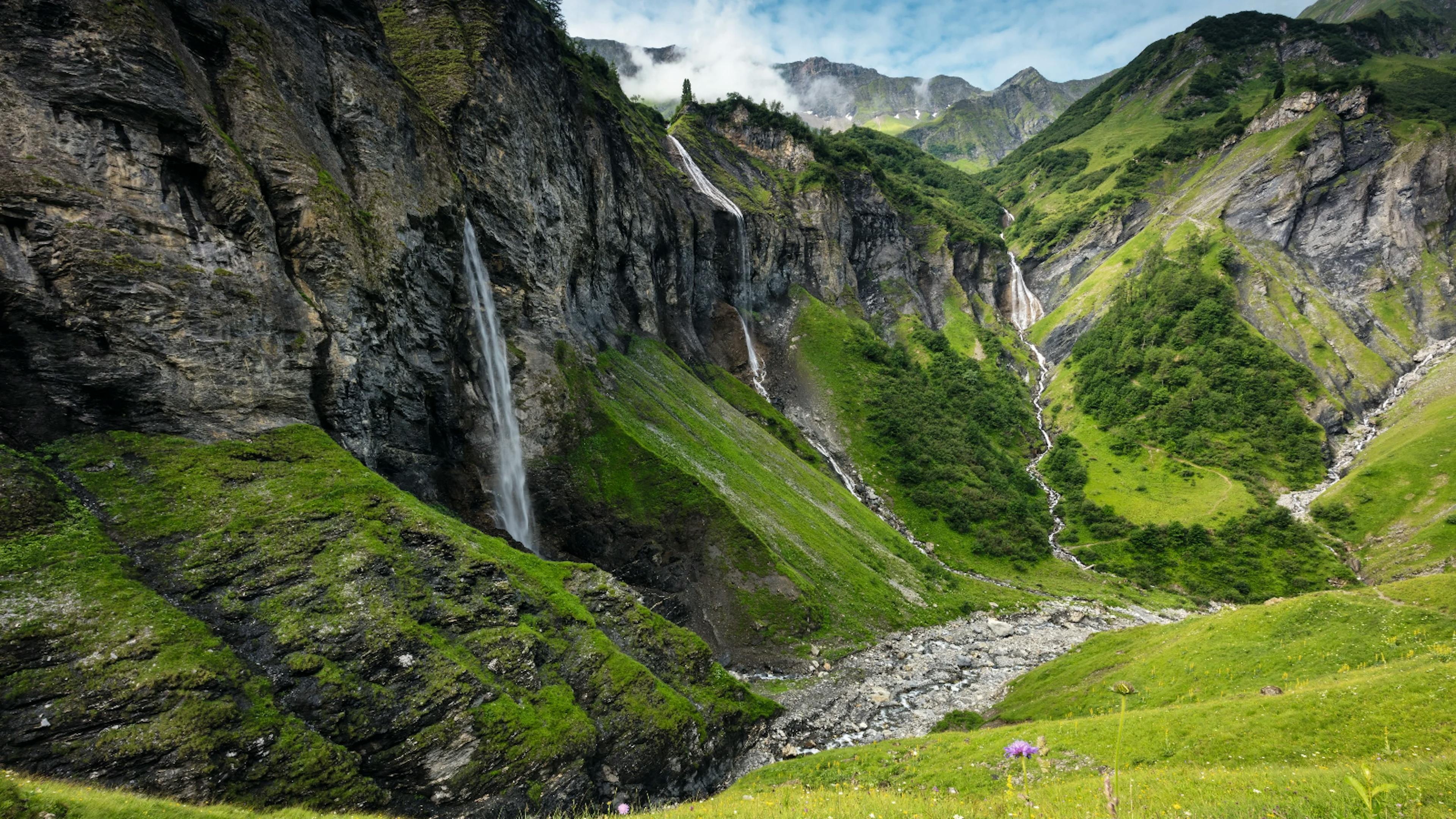 Mels Weisstannental avec des chutes d'eau, des prairies verdoyantes et des montagnes