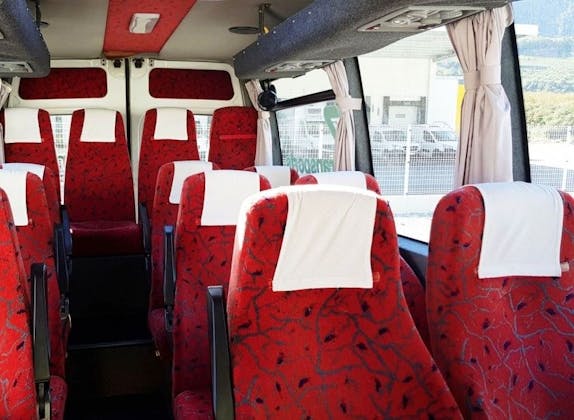 Minibus: Interni di un veicolo confortevole con sedili rossi per viaggi di gruppo