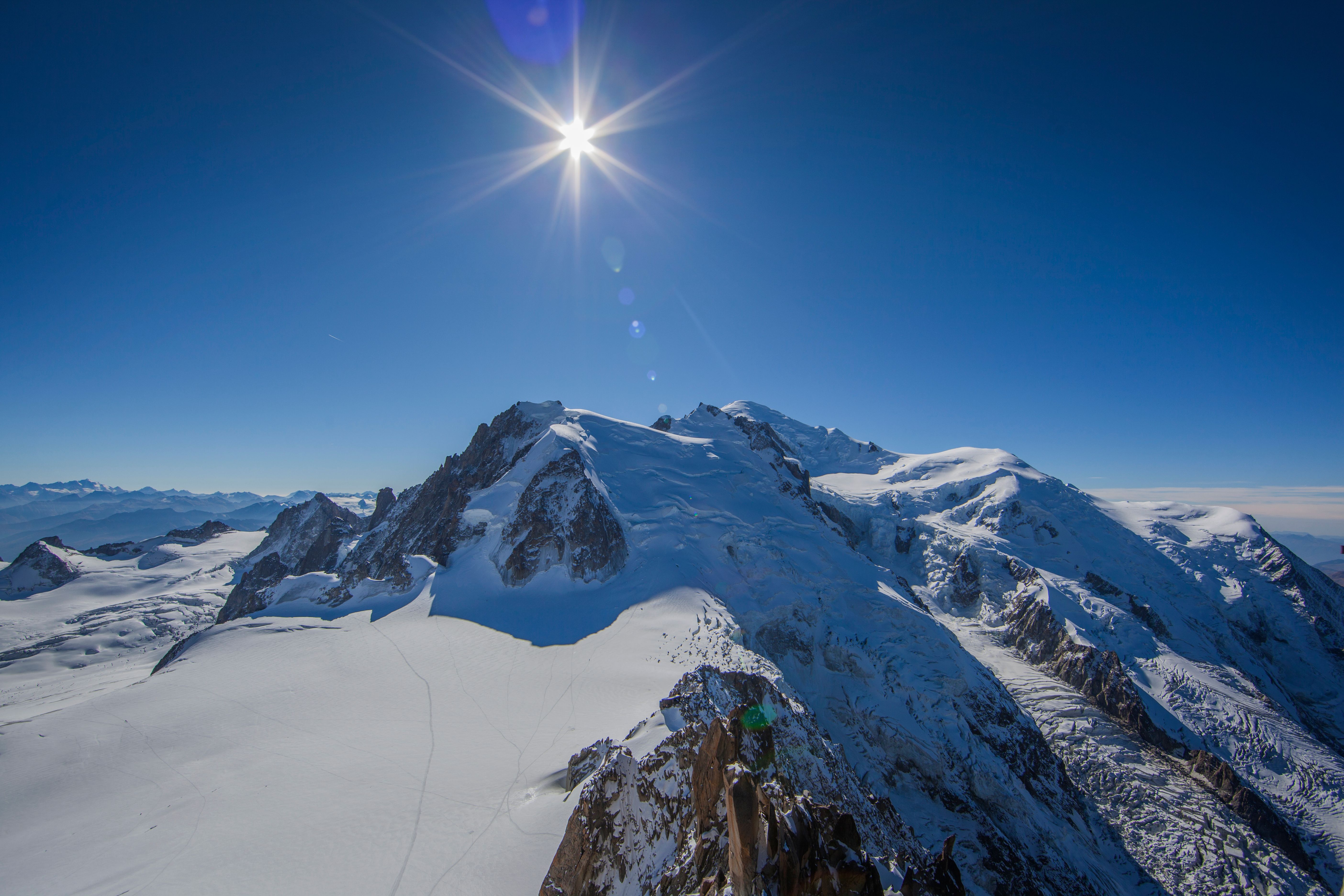 Mont Blanc di bawah sinar matahari yang cerah, puncak bersalju, langit cerah, pemandangan gunung yang menakjubkan.