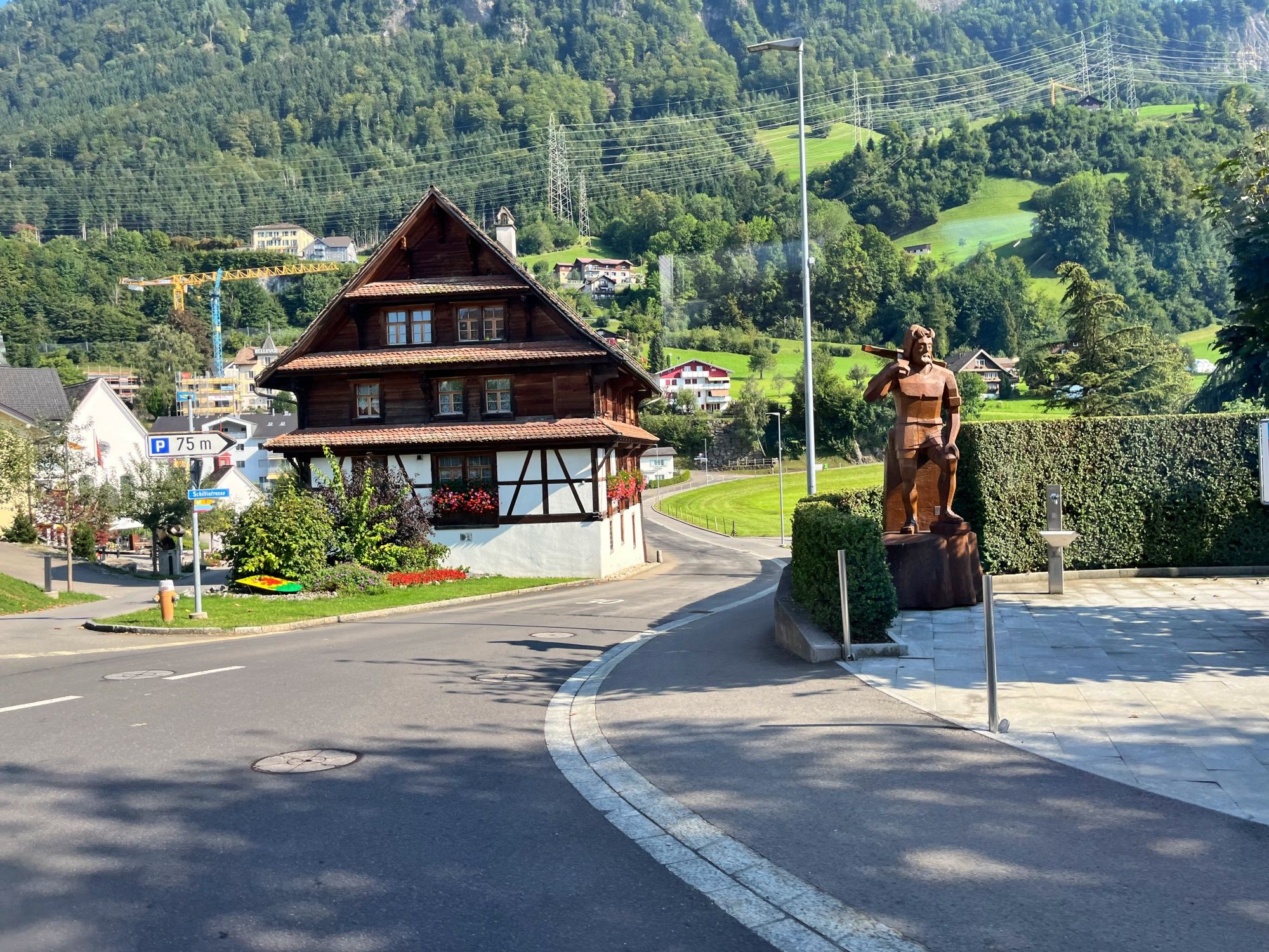 Morschach: Vista su scultura elegante e casa tradizionale in un paesaggio alpino