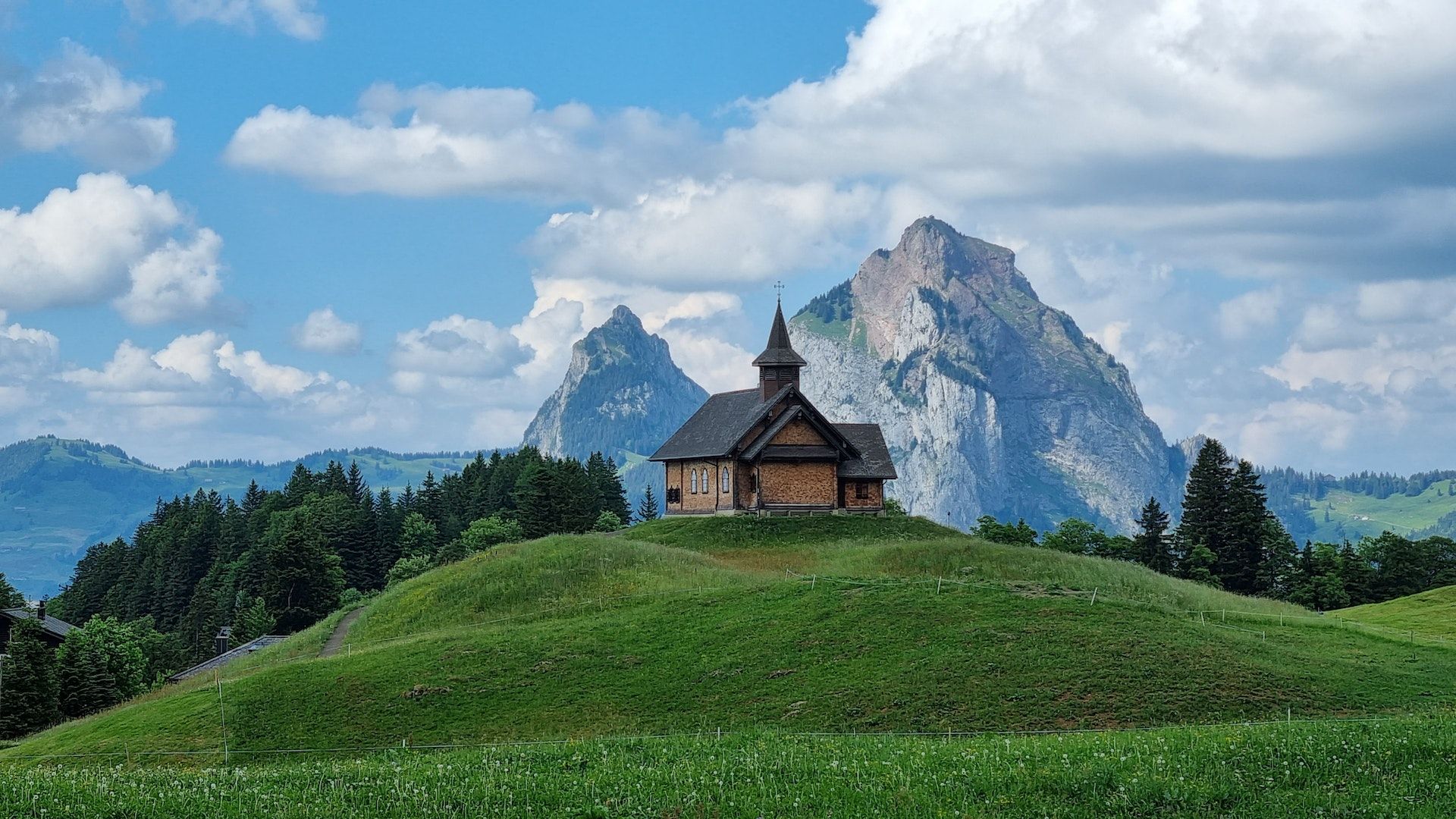 Morschach: Edificio pittoresco di fronte a maestose montagne nella natura con atmosfera estiva.