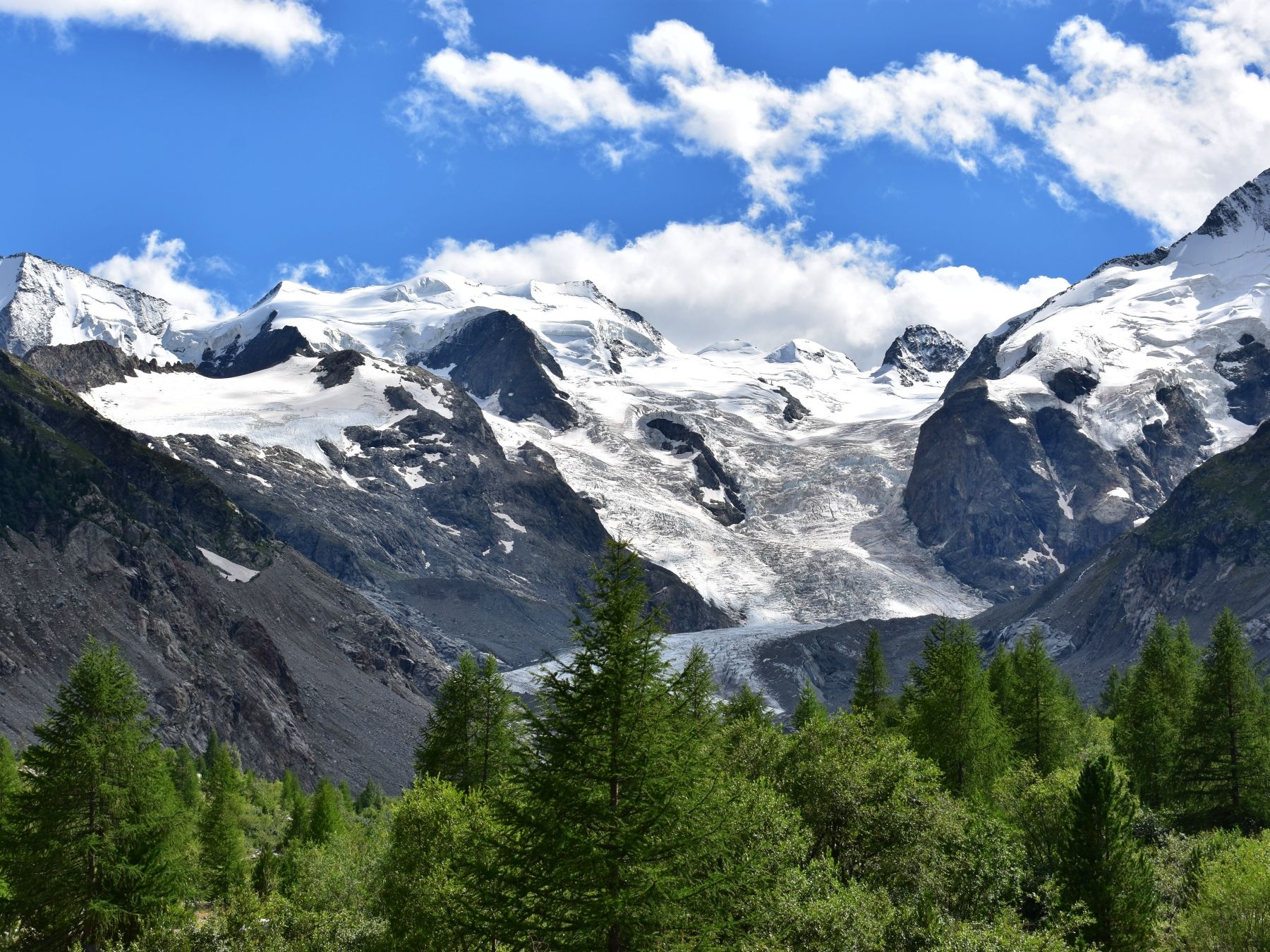 Ghiacciaio Morteratsch con neve e montagne sotto un cielo blu.