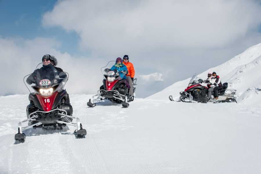 Tour en motoneige dans le paysage hivernal avec des conducteurs sur des chemins réguliers.