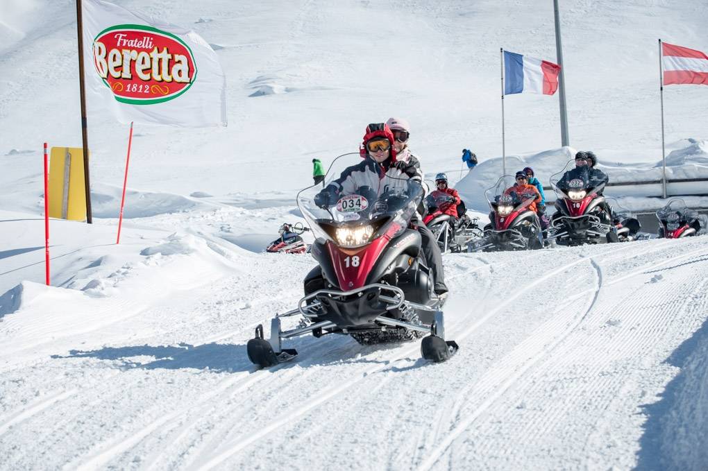 Balade en motoneige au col de Splügen avec de la neige et des participants.