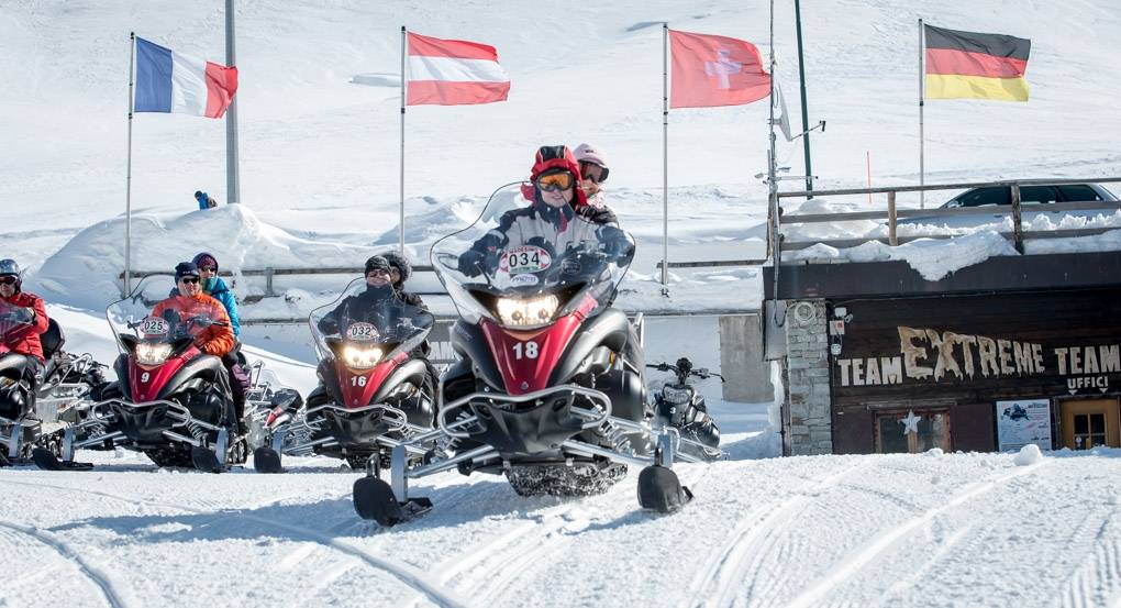 Tour en motoneige sur le Splügenpass avec plusieurs conducteurs en vêtements d'hiver