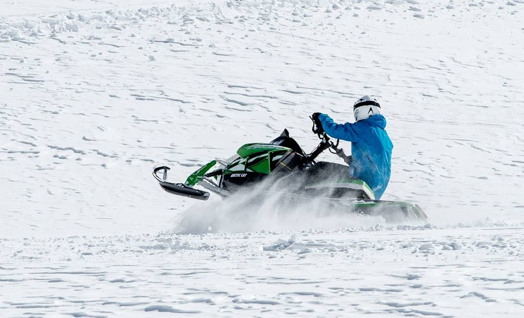Tour en motoneige en Suisse en 2023 à travers des terrains enneigés.