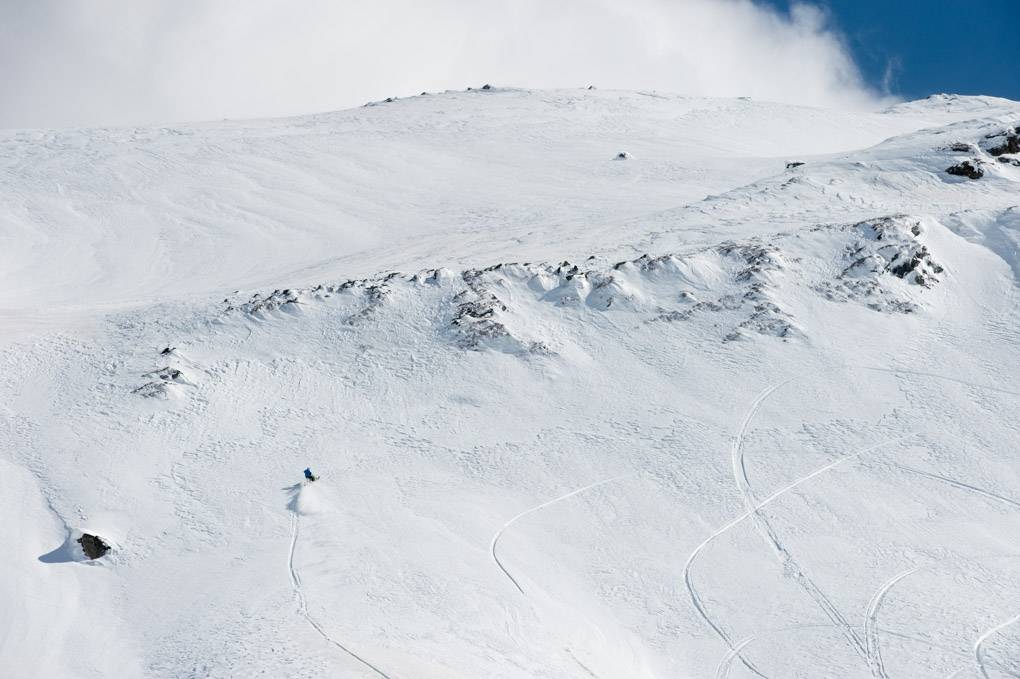 Balade en motoneige dans la neige, nuages clairs, traces fraîches.