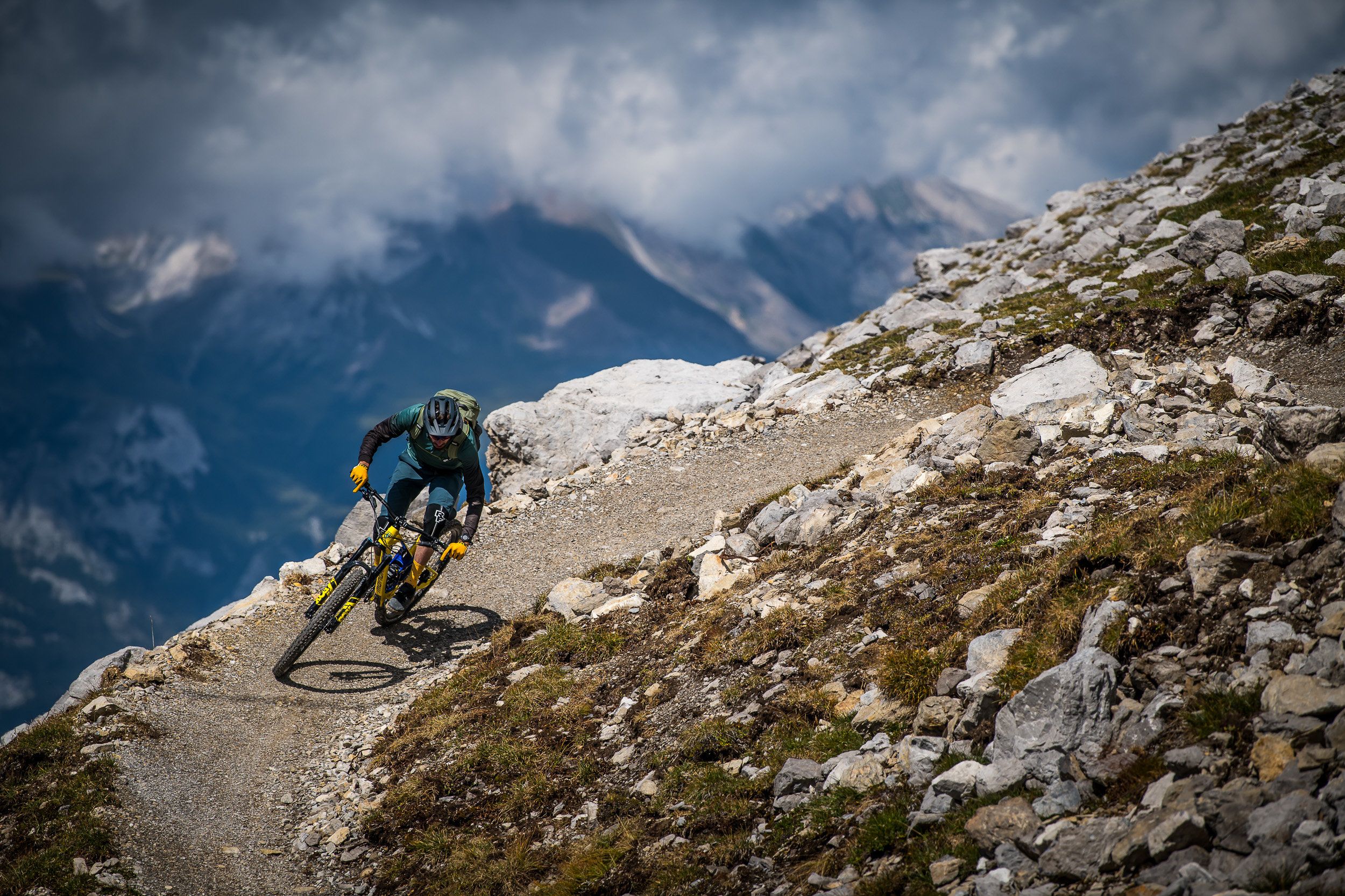 Mountainbike i Davos på bergssida, föraren på smal stig med cykel